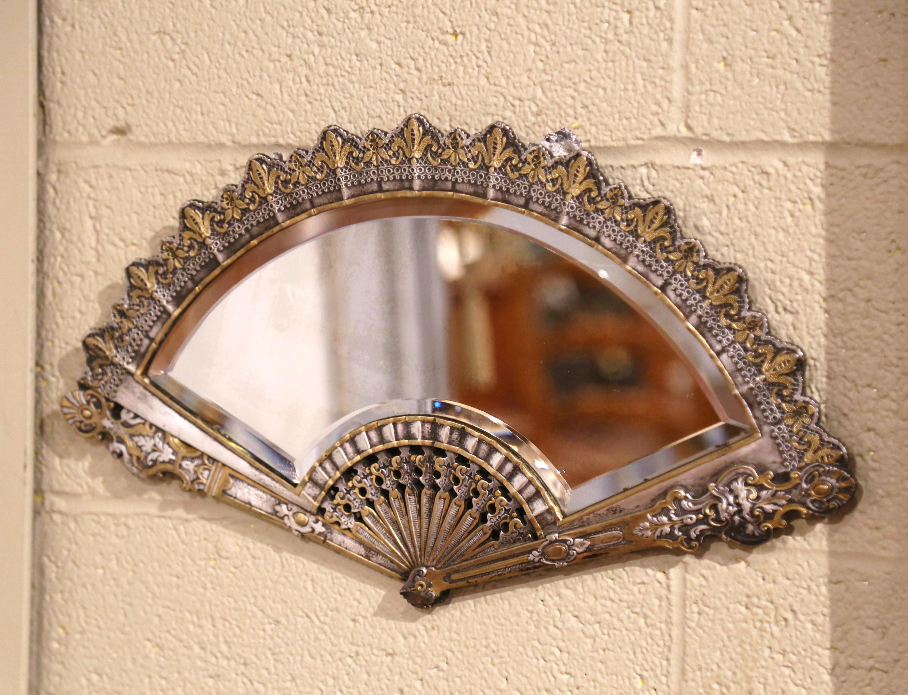 Decorate a wall, a vanity, or dresser with this intricate fan mirror. Crafted in France, circa 1880, and unique in shape, this heavy bronze features finely chiseled gilt detailing throughout. The wall hanging mirror is in excellent condition