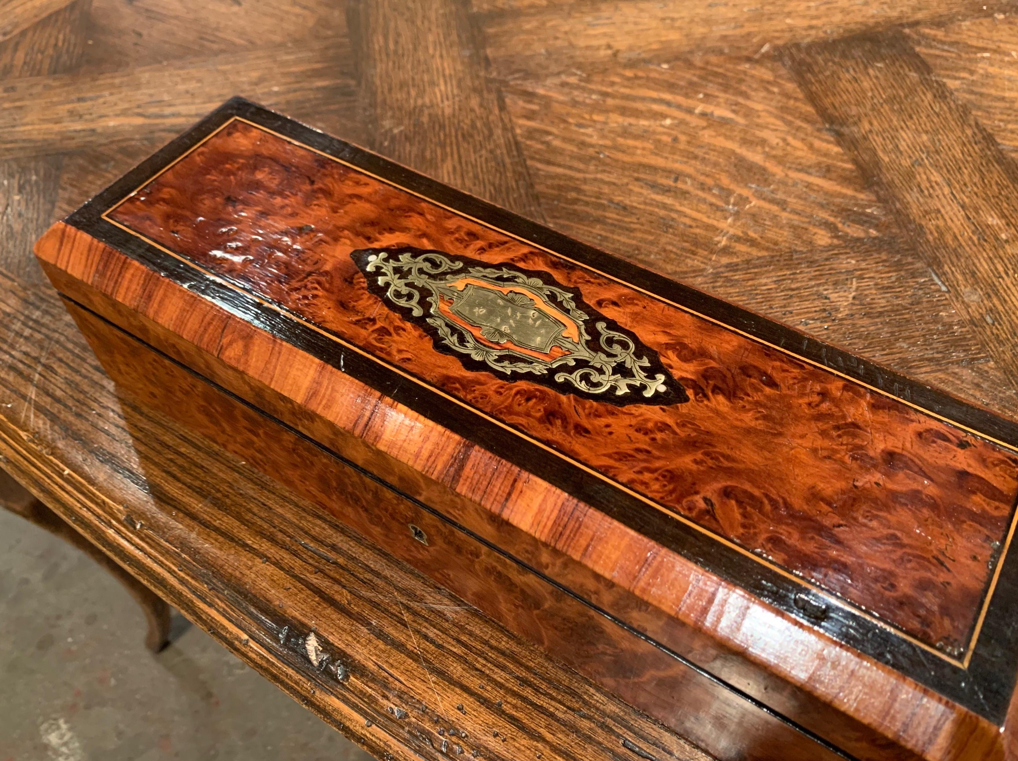Keep your valuables organized and safe in this elegant antique box; crafted in France circa 1870 and rectangular in shape, the box features a burl walnut veneer and is decorated on the top with a brass inlaid medallion. The inside is upholstered