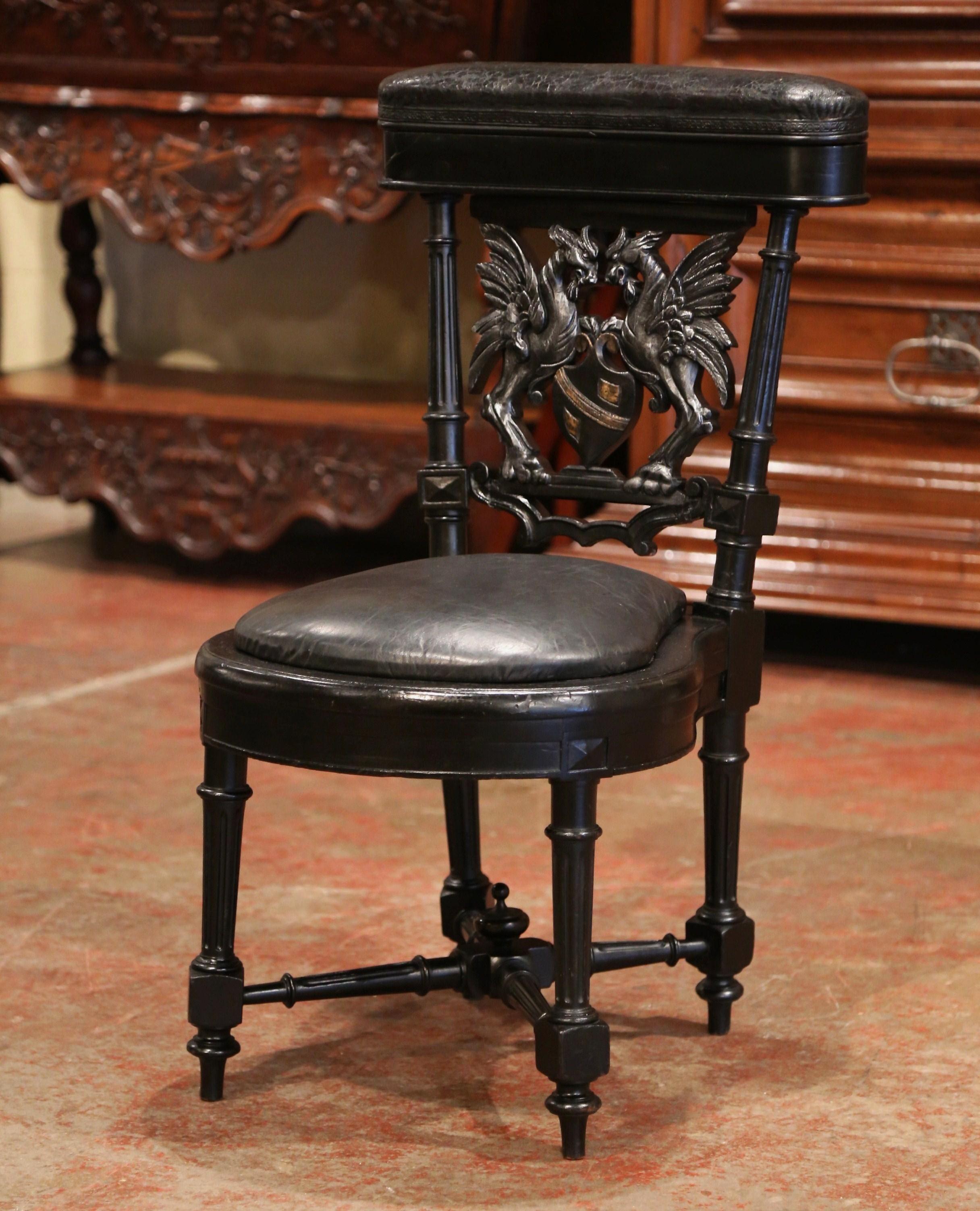This elegant antique cigar chair was crafted in France, circa 1870. The blackened chair stands on four tapered and fluted legs joined at the bottom with a stretcher and decorative central finial, and features exquisite carvings including a family