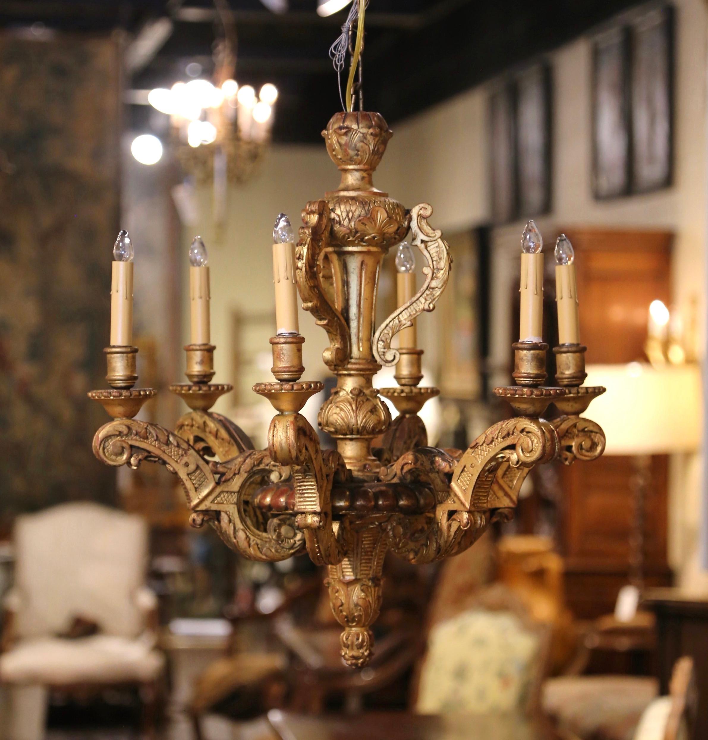 Decorate a dining room or a den with this elegant antique wooden chandelier. Crafted in France circa 1880, the light fixture is round in shape and features six arms of equal lengths around the thick intricately carved central stem; each curled arm