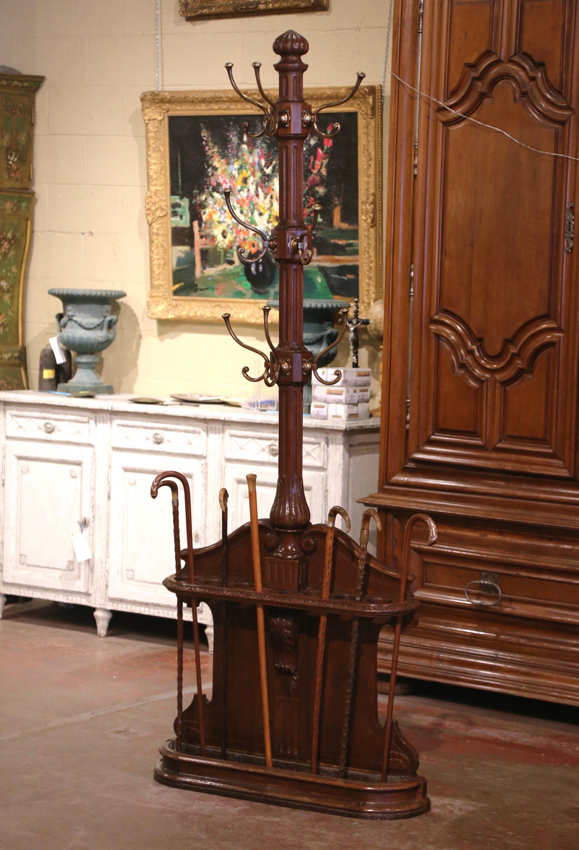 This elegant antique coat rack was crafted in northern France, circa 1870. The tall stand sits on a straight plinth, and features a central stem dressed with eight bronze double hooks for coats and hats; it is further embellished with a carved cone