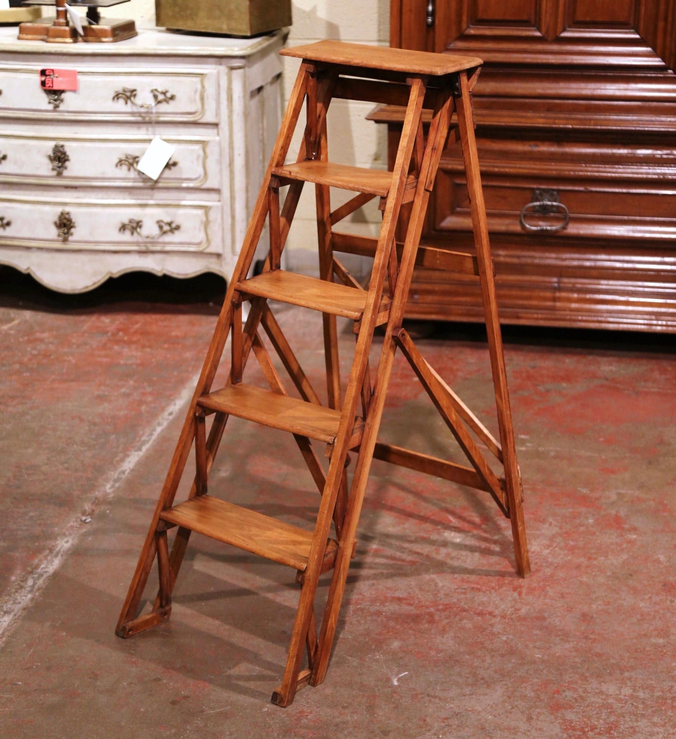 Crafted in Lyon, France circa 1880 and made of walnut, the stairs features five graduated steps to one side and connected to the opposing support with a wooden and metal action folding mechanism. Practical and useful, the ladder can be put away if