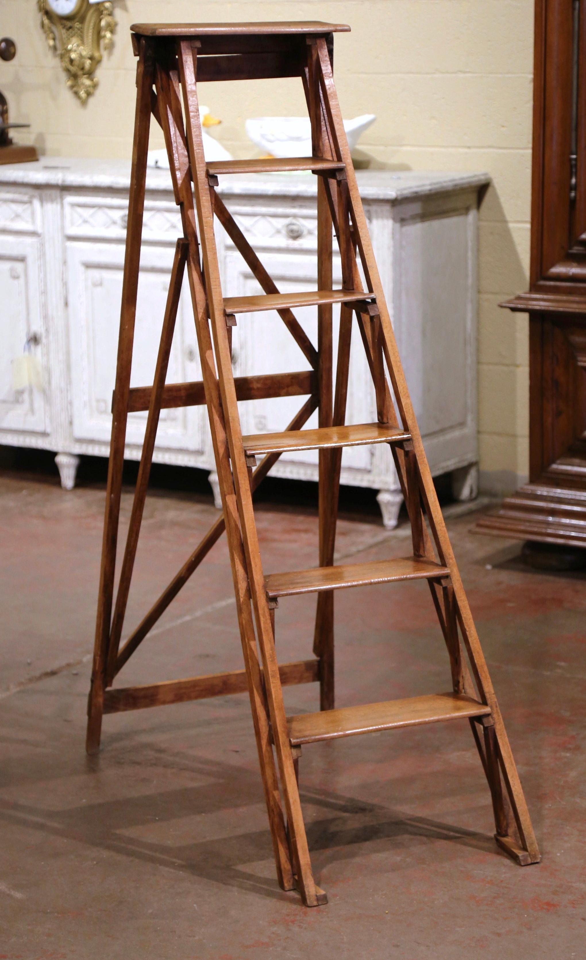 Crafted in Lyon, France circa 1880 and made of walnut, the stairs features six graduated steps to one side and connected to the opposing support with a wooden and metal action folding mechanism. Practical and useful, the ladder can folded and put