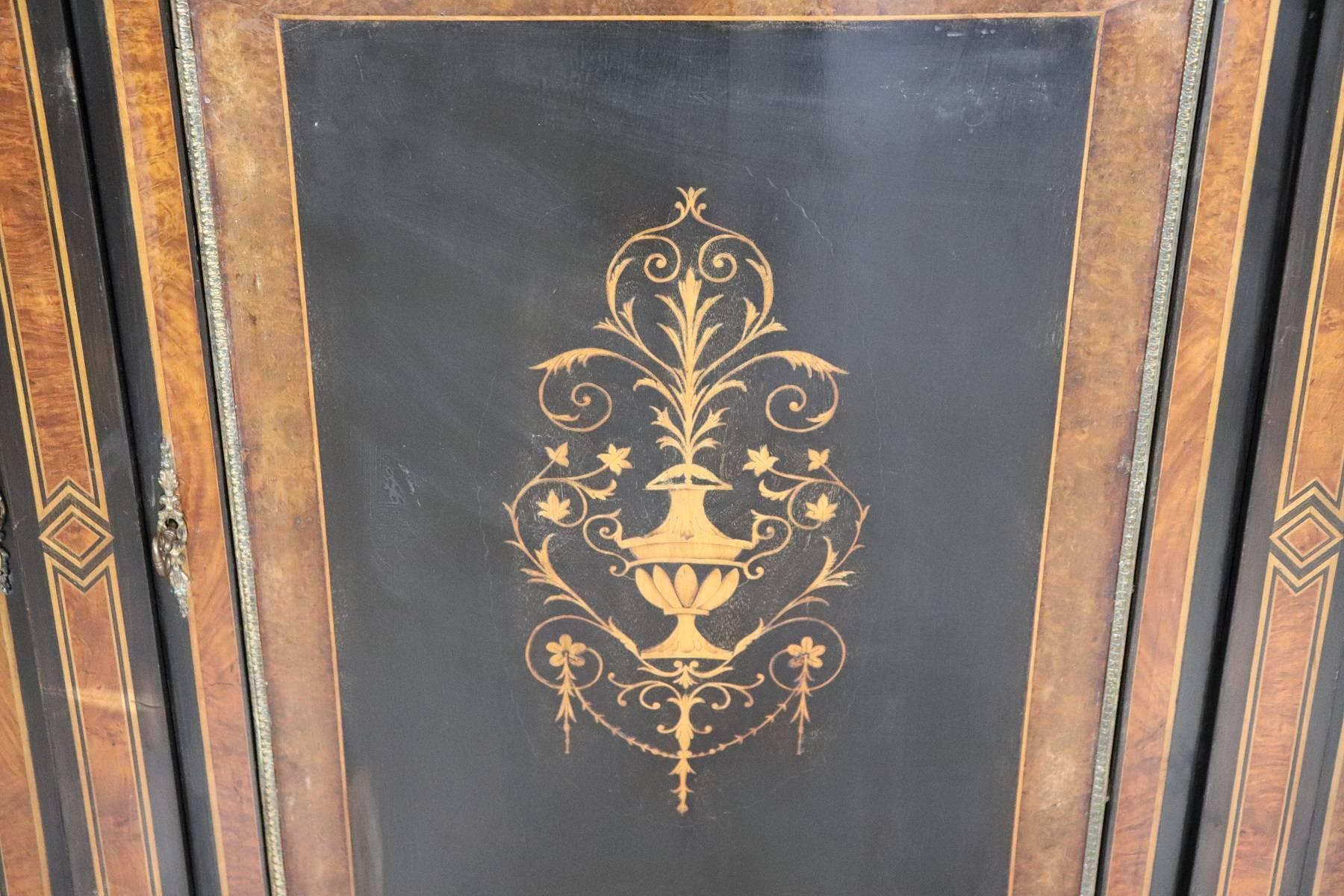 Antique ebonized and inlay French Napoleon III bombe cabinet with vetrine, circa 1860. Item features a floral decorated urn form inlaid central door.
elegant golden brass frames. Inside in the velvet-covered showcase part. Elegant cabinet!
signs
