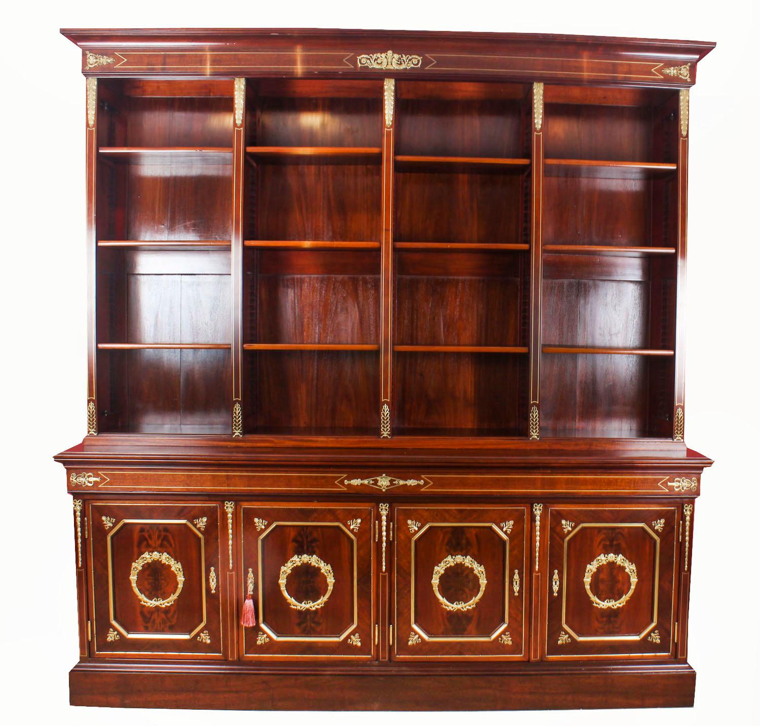 This is a spectacular large exceptional quality antique French Napoleon III Empire Flame mahogany bookcase with fabulous ormolu mounts, circa 1870 in date.

The bookcase rising from a shaped plinth base, the four lower lockable panelled doors house