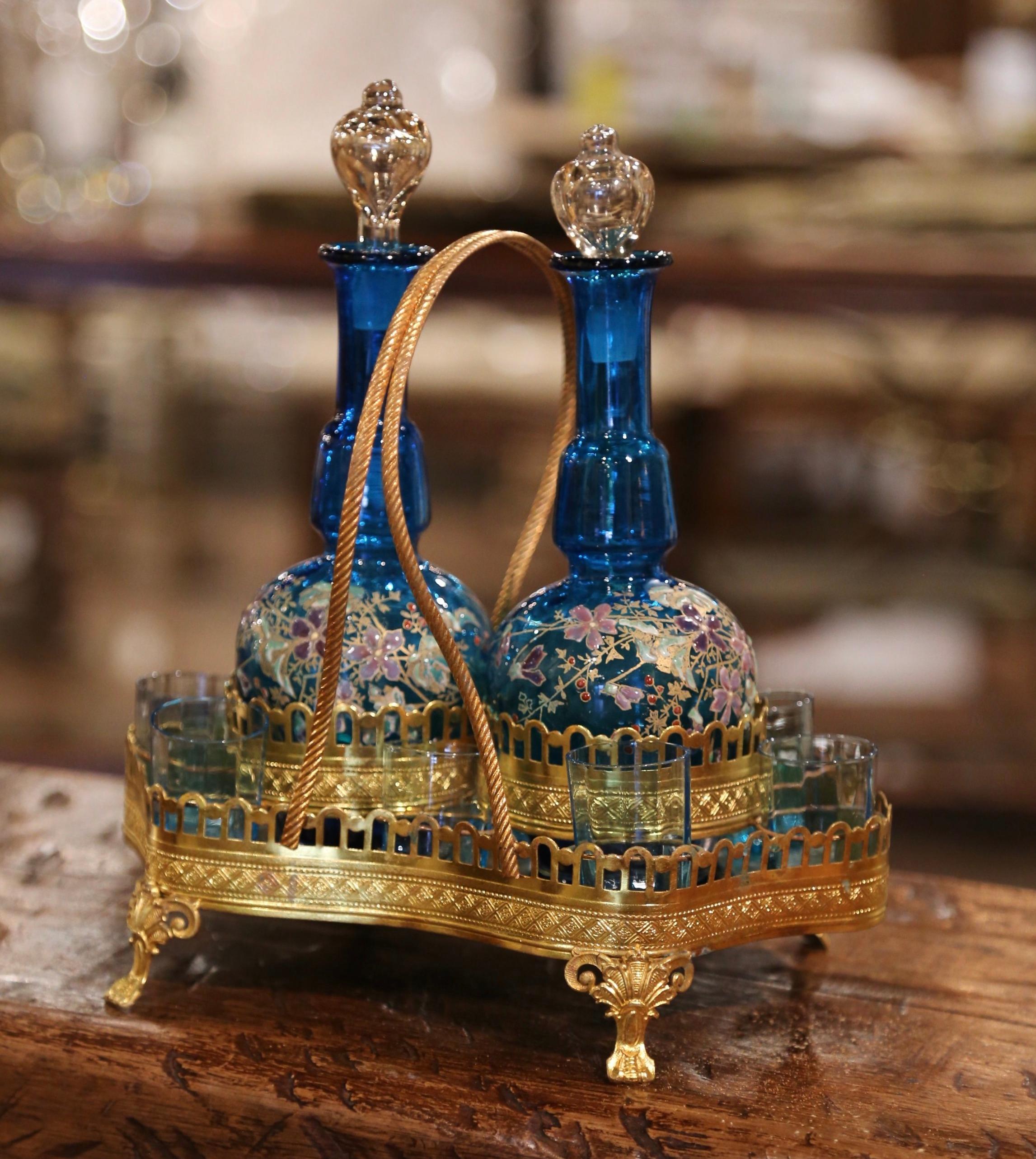 Decorate a bar area with this elegant and colorful antique liquor cave. Created in France circa 1880, the bar essential sits on small scrolled feet over a serpentine and bombe base decorated with a pierced rim. The set dressed with a large rope form