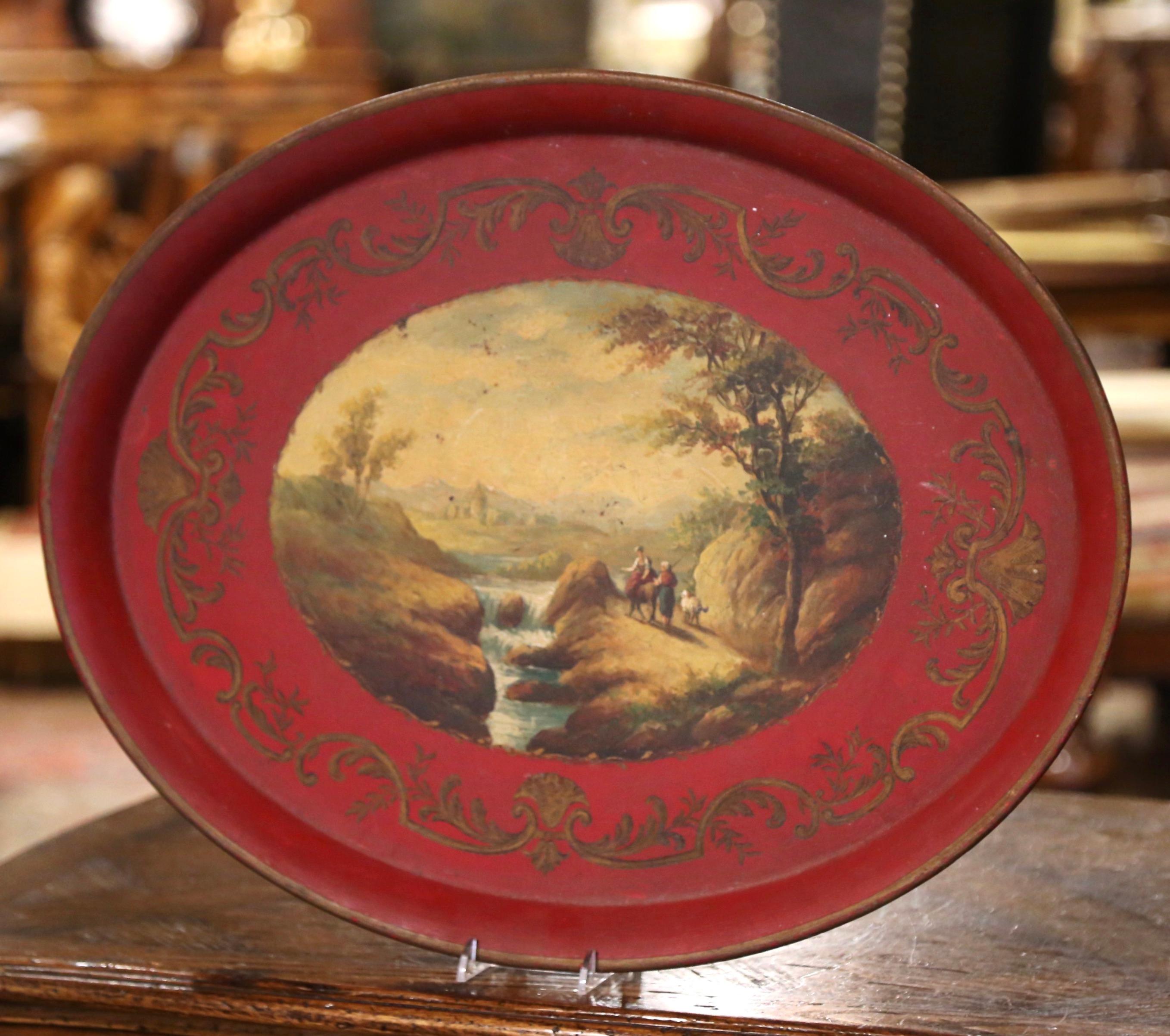 Place this elegant antique tole tray on a coffee table or hang it on a wall. Crafted in France, circa 1870, and oval in shape, the colorful platter is decorated with a hand painted center medallion depicting a landscape in rural France with a castle