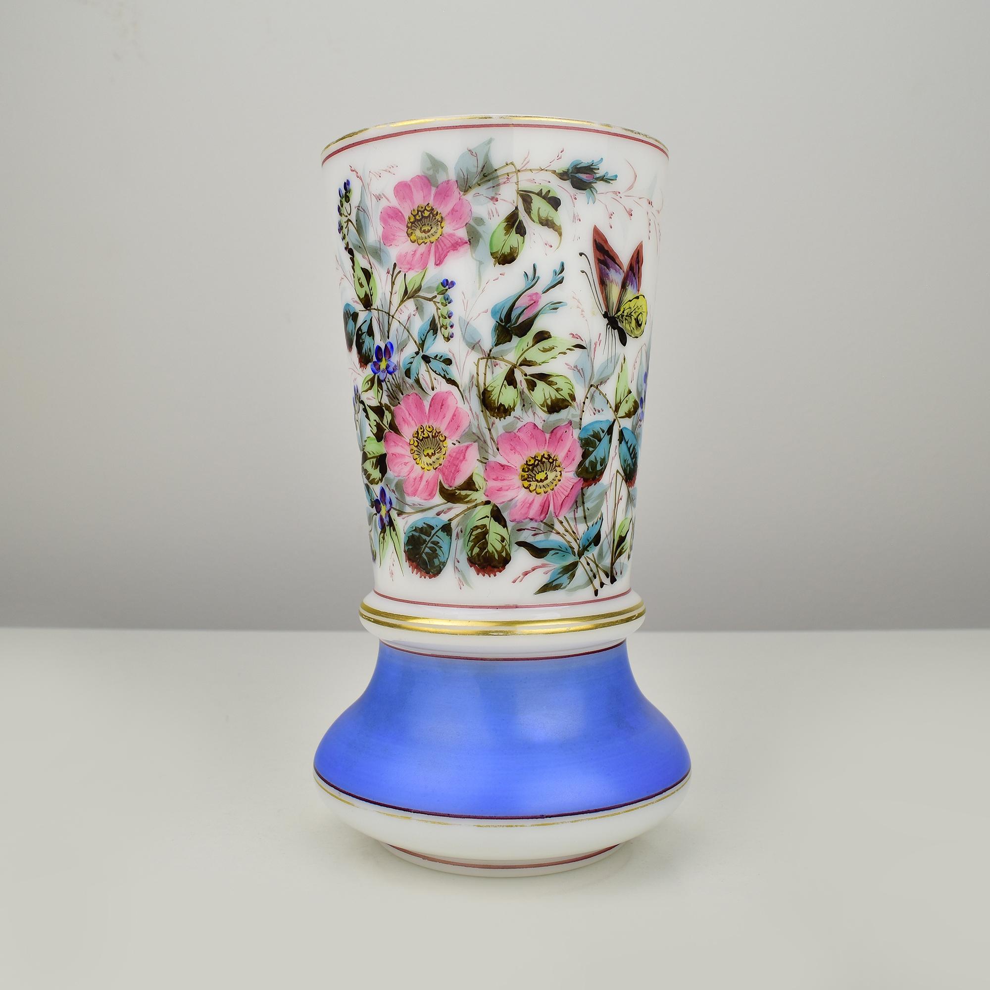 Un opulento vaso in vetro opalino dipinto a mano, probabilmente realizzato da Baccarat. Delizioso dipinto a mano con un ricco bouquet floreale di rose selvatiche e fiori di nontiscordardime, linee dorate e una fascia blu reale a contrasto sulla base.