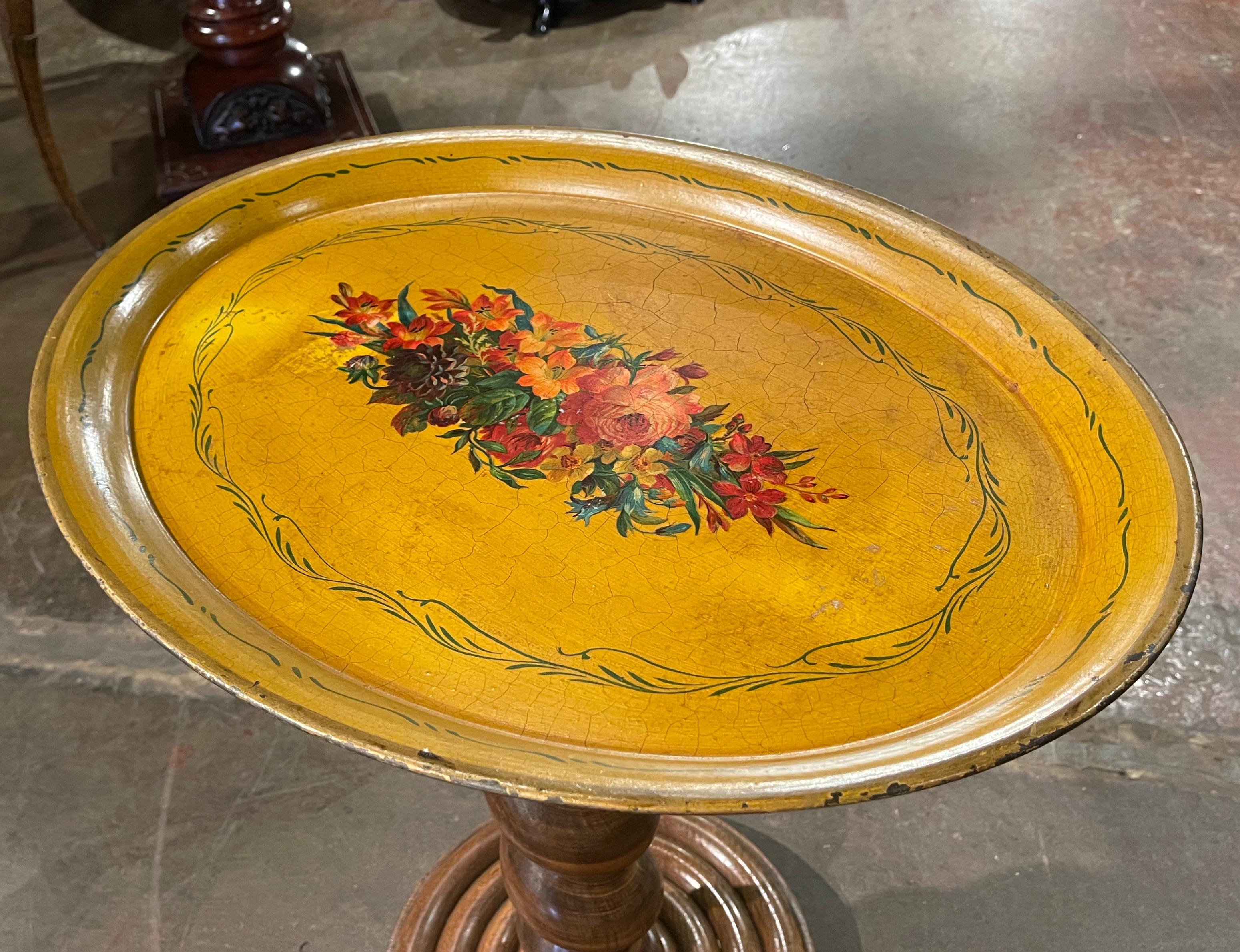 Place this elegant antique tole tray on a coffee table or hang it on a wall. Crafted in France, circa 1870, and oval in shape, the colorful platter is decorated with a hand painted center medallion featuring floral motifs; it is further embellished