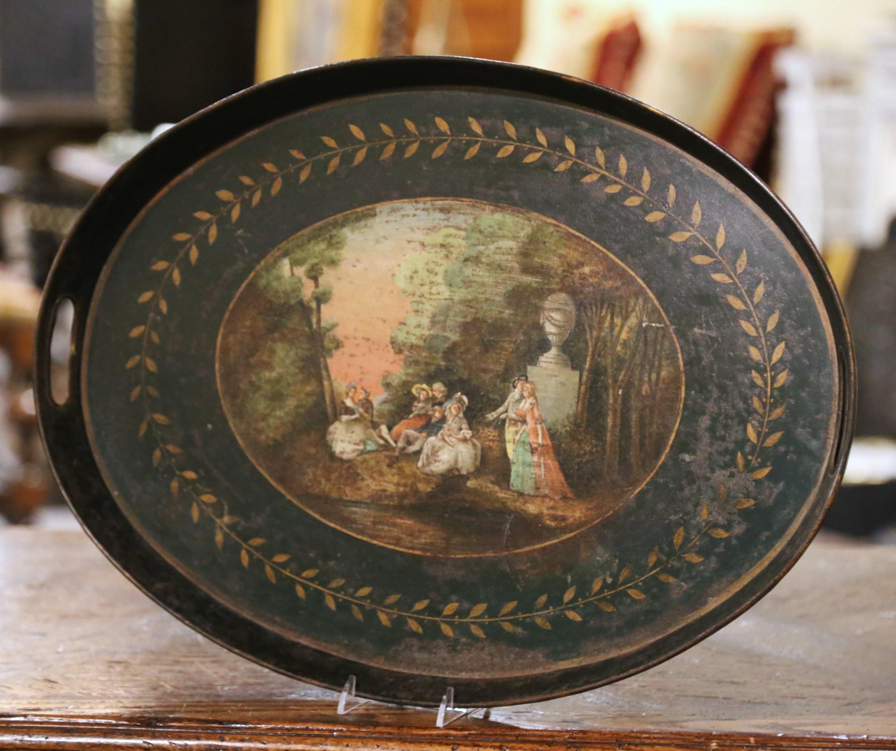 Place this elegant antique tole tray on a coffee table, in a master bathroom, or hang it on a wall. Crafted in France, circa 1870, and oval in shape, the colorful platter with pierced side handles, is decorated with a hand painted center medallion