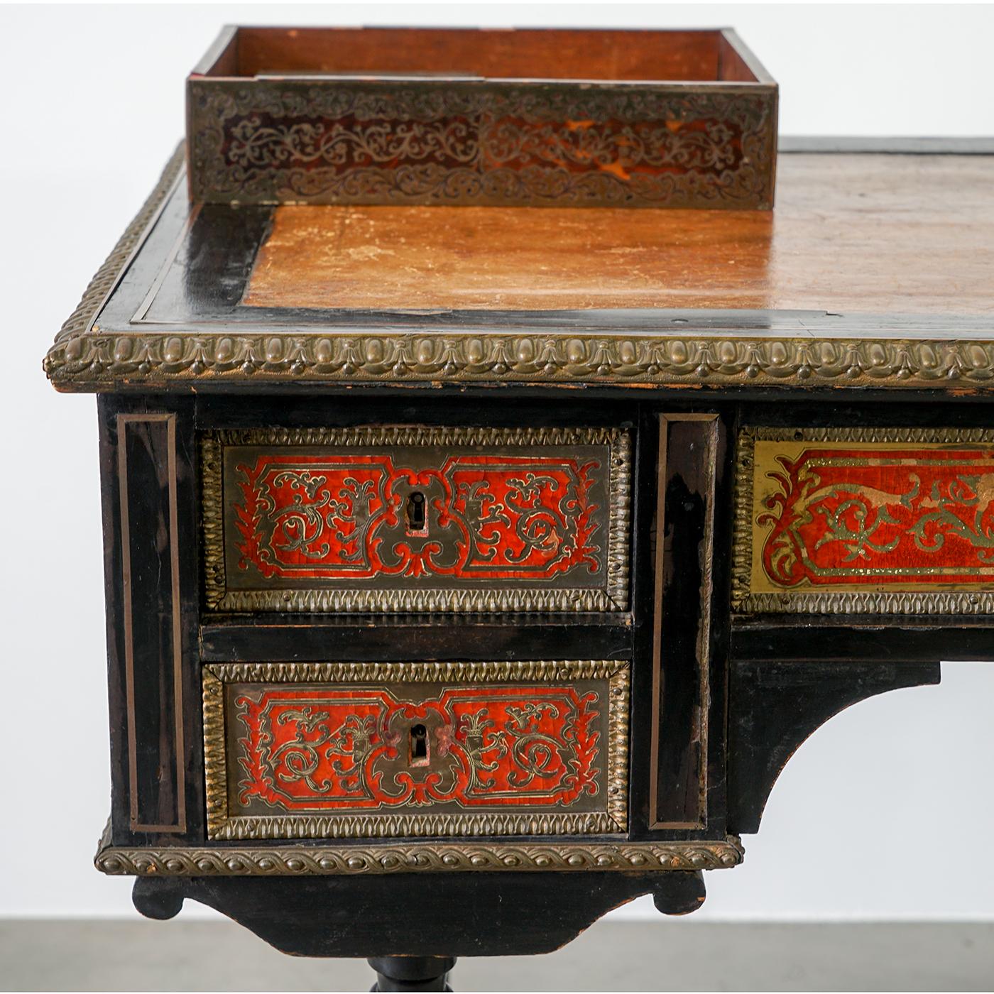 This beautiful second generation desk in Boulle marquetry was produced in France in the 19th century. This unique piece is handmade from ebonized wood, each side with two side drawers and a wider drawer in the middle. The drawers are not in their