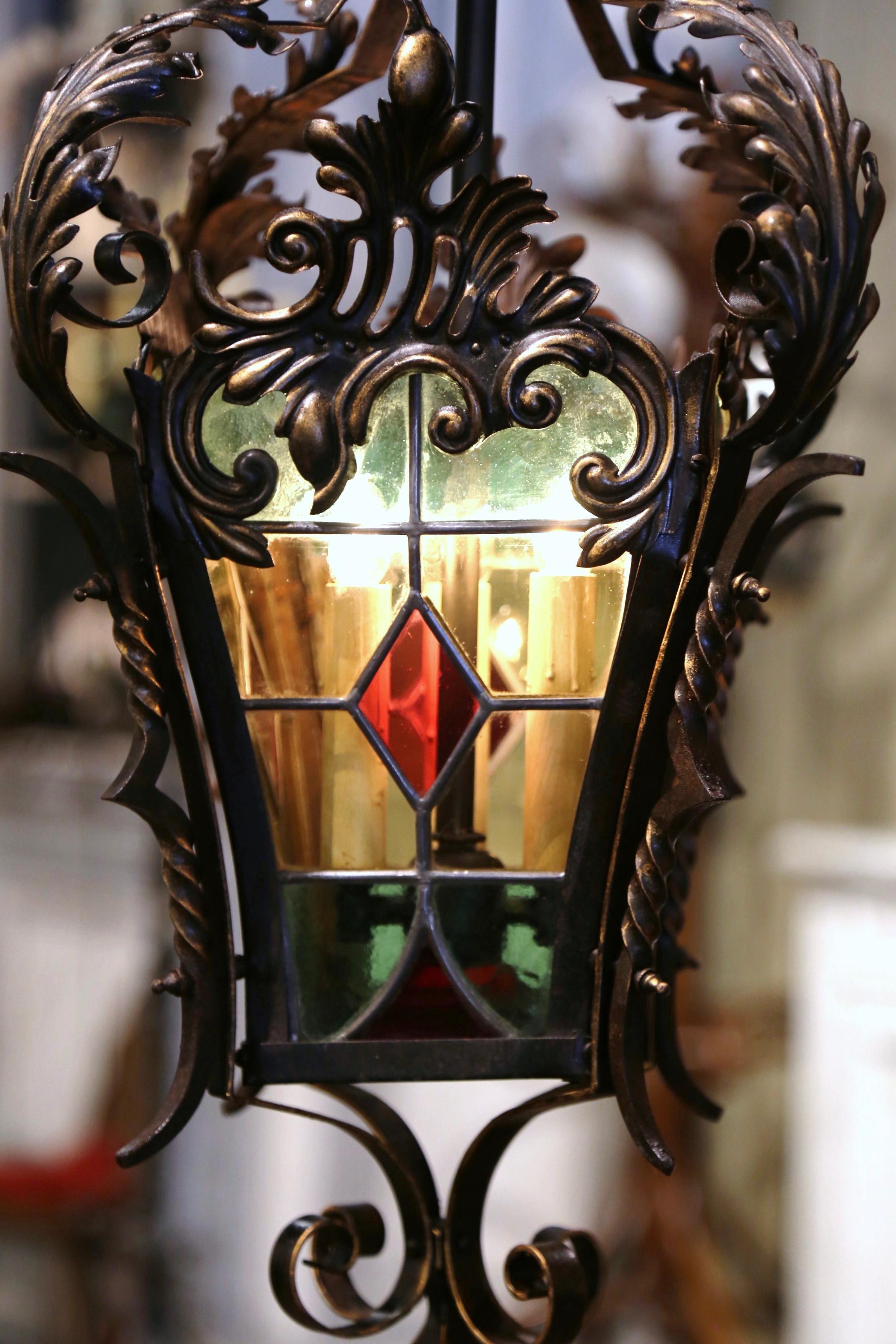 Hang this elegant, Gothic lantern in your entry or powder room. Crafted in France, circa 1870, the antique light fixture features four hand-painted, stained glass panels in the red, green and yellow palette, which are embellished with foliage and