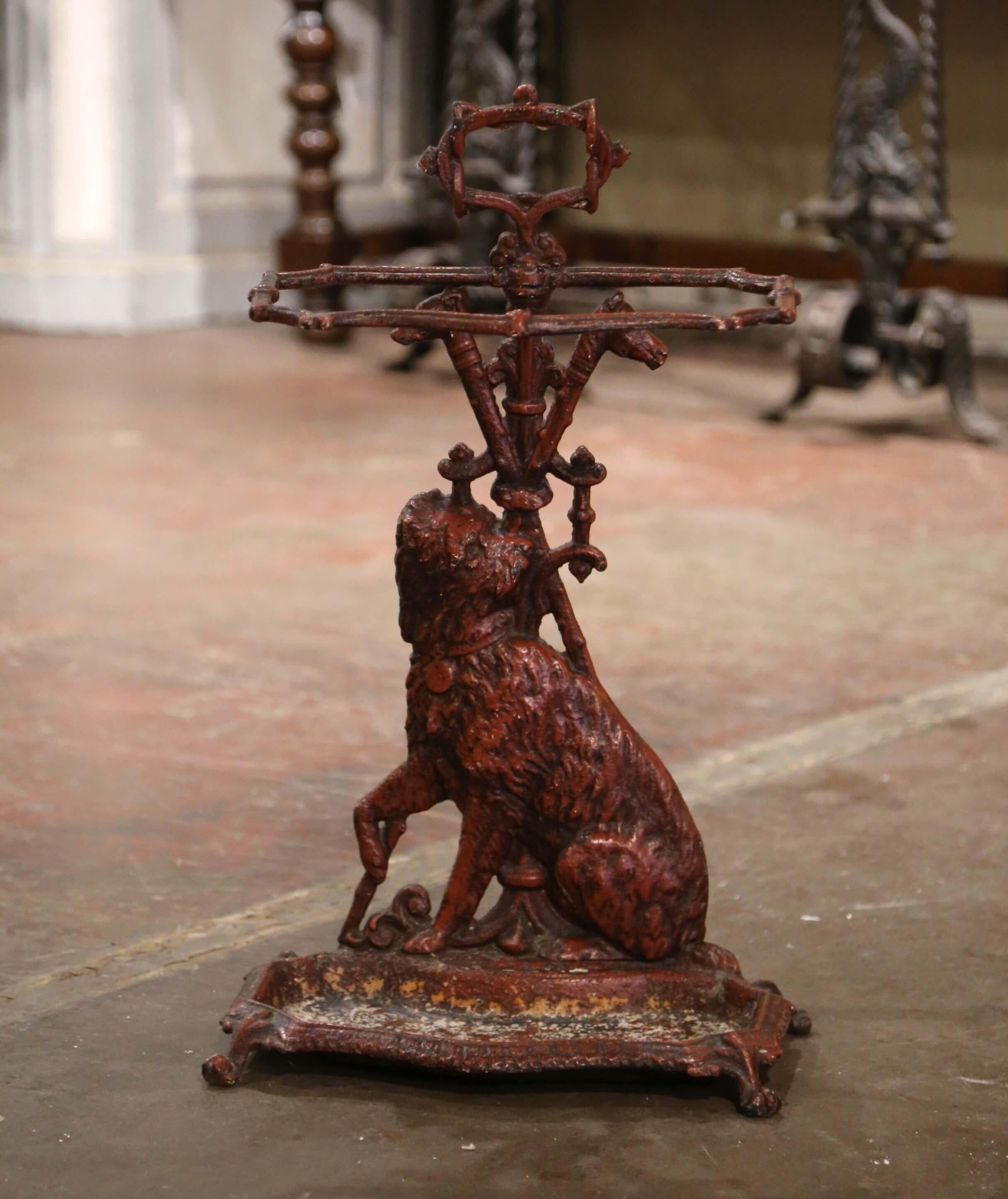 Décorez une entrée ou un vestibule avec cet élégant porte-parapluie ou porte-canne ancien. Fabriqué en France, vers 1860, le support repose sur quatre petits pieds en forme de feuilles au-dessus d'un plateau de trempage, et présente une figure de