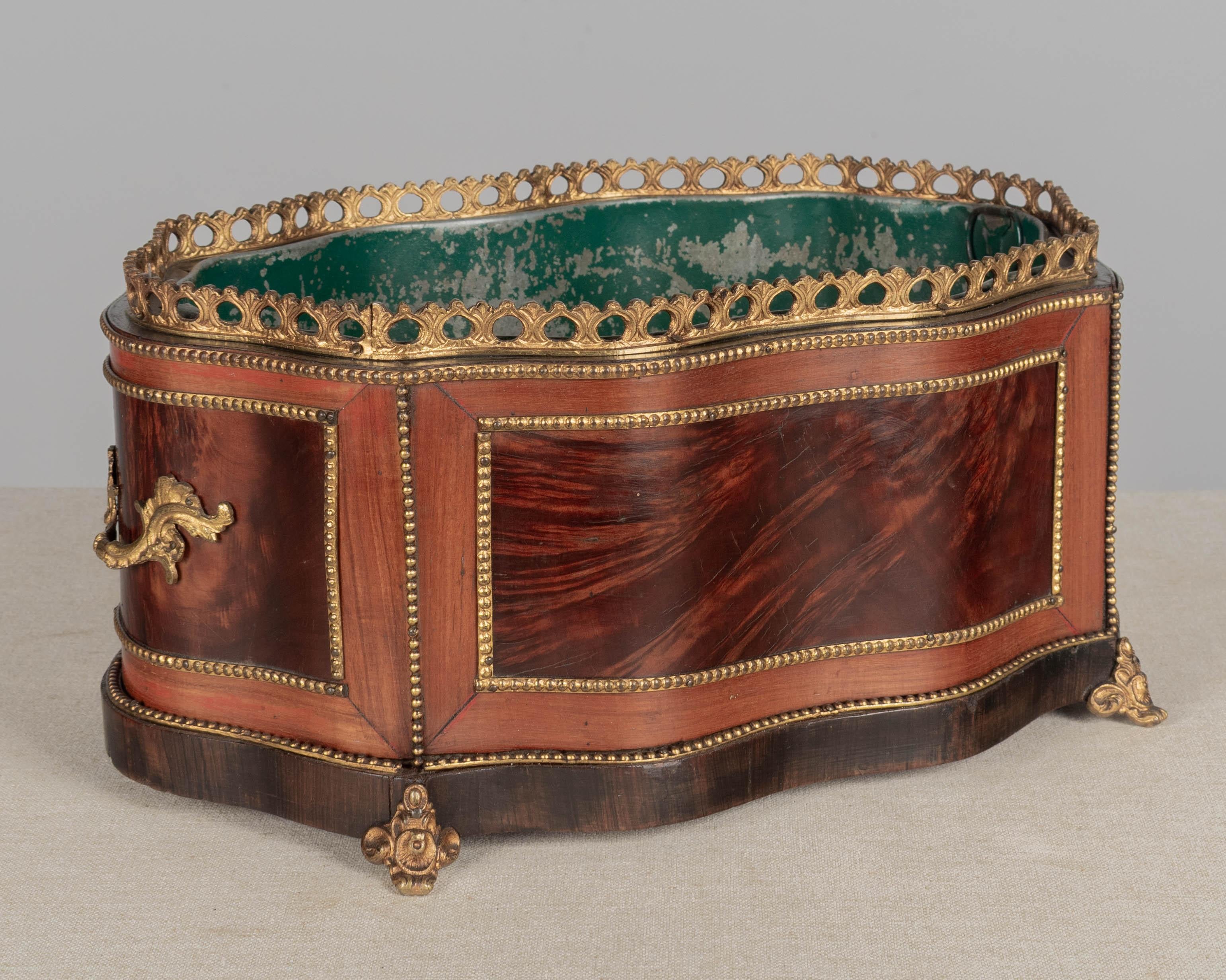 A late 19th century French Napoleon III marquetry jardinière with inlaid veneers of burled walnut and mahogany. Bronze-mounted with two handles, gallery and bead trim. Zinc liner. All original. A beautiful planter for the display of orchids. Overall