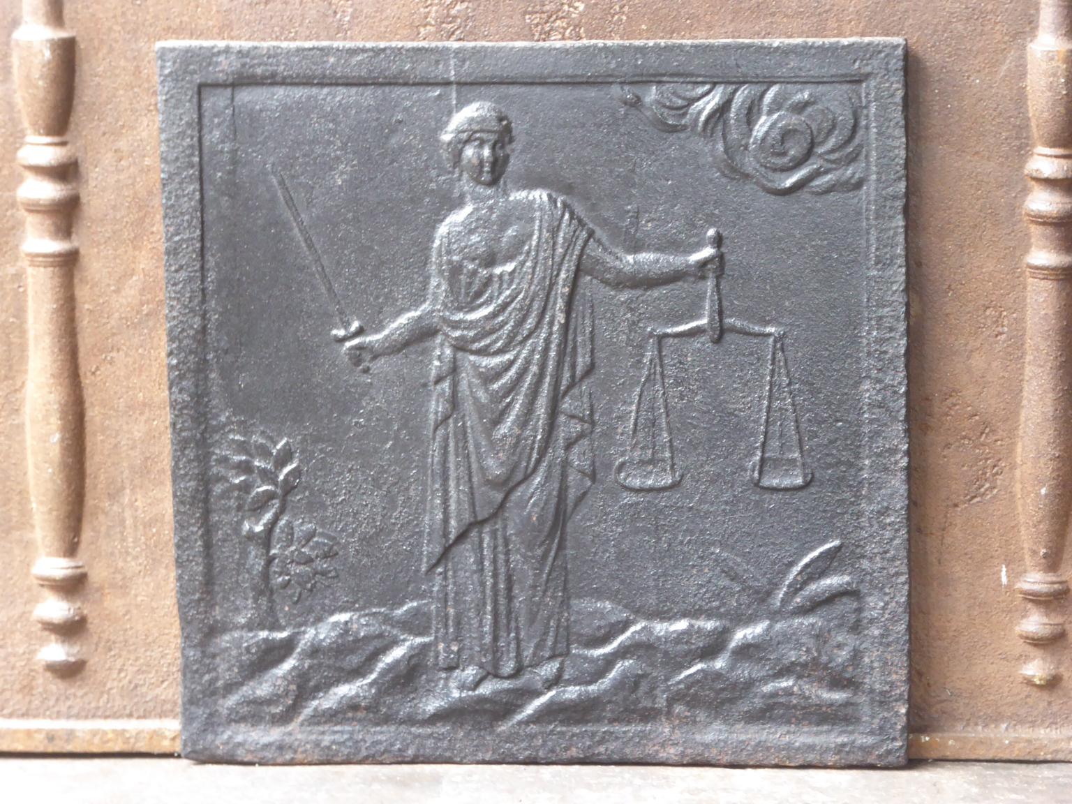 19th century French Napoleon III fireback with the Goddess Justice. The personification of justice balancing the scales of truth and fairness dates back to the Goddess Maat, and later Isis, of ancient Egypt. 

The fireback is made of cast iron and