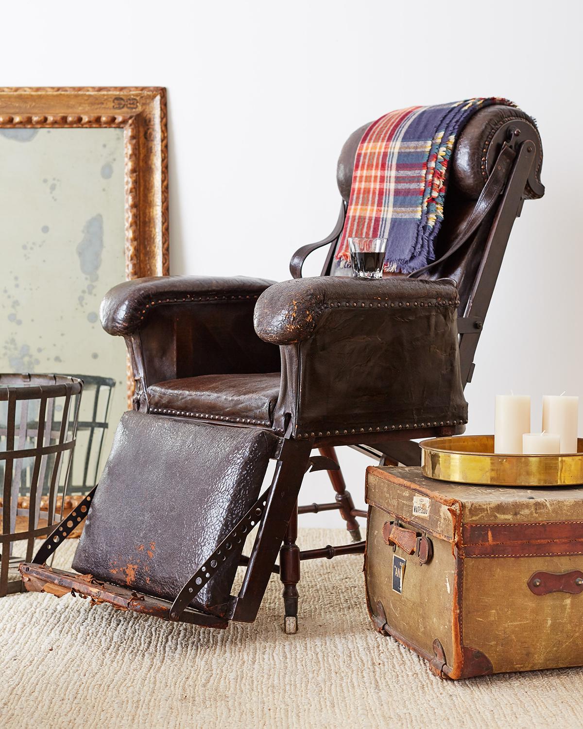 Fantastic 19th century French Napoleon III period leather reclining armchair or lounge chair. Features a mahogany frame covered with rich, distressed dark leather. The leather surfaces have brass tack nail head borders and thick padding. Functioning