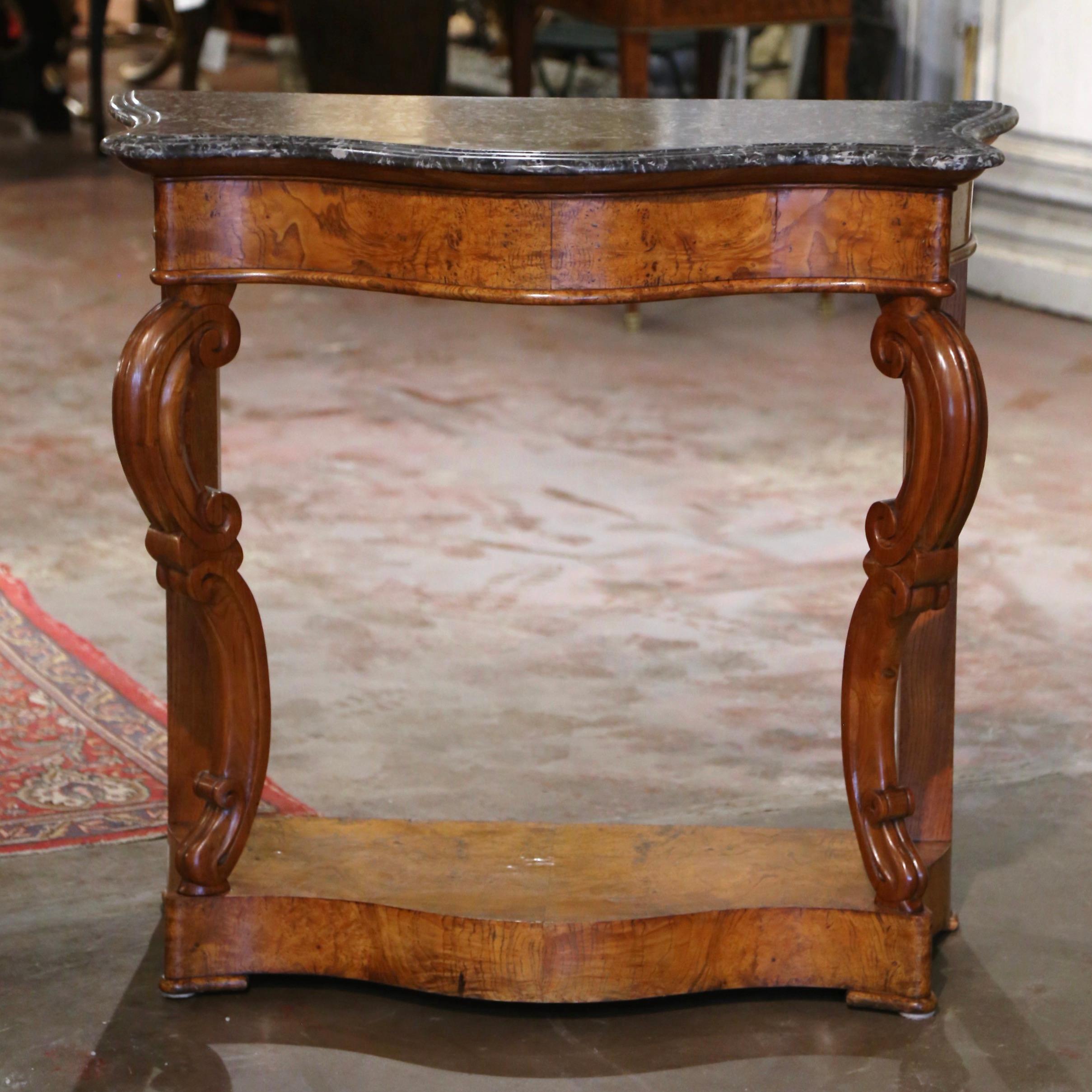 Decorate an entry or hallway with this elegant antique console. Crafted in France circa 1870, the table stands on two front cabriole legs with double volutes ending with hand carved acanthus leaf motifs; the console is further dressed with a lower