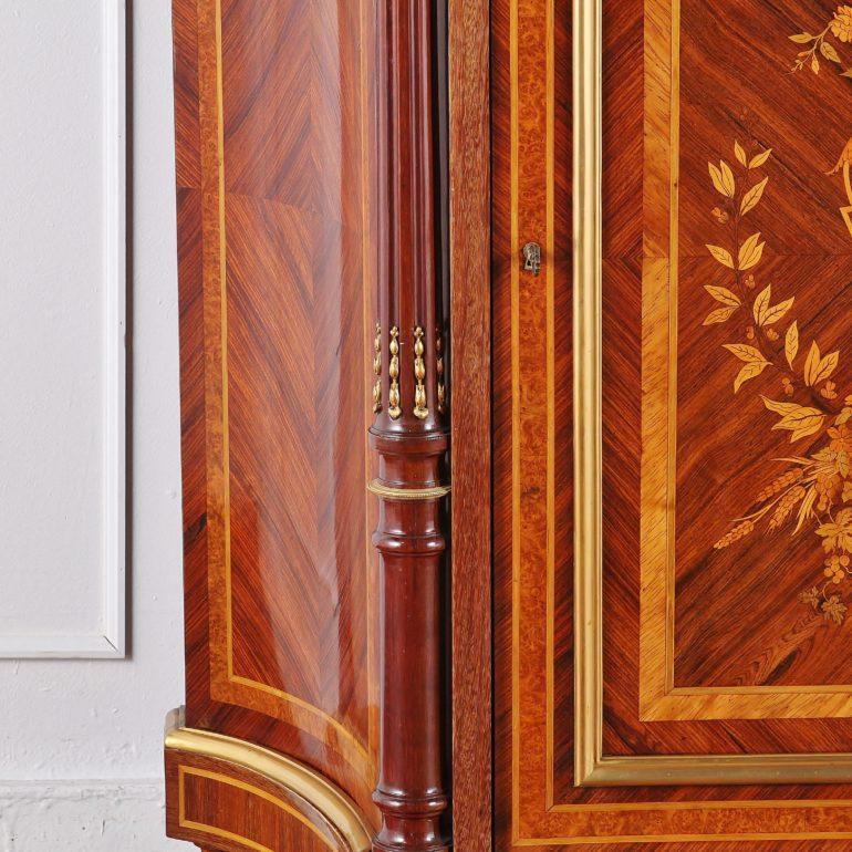 A French Napoleon III mahogany side cabinet profusely inlaid with various exotic veneers of mahogany, kingwood, amboyna, boxwood etc. The door features a highly-detailed marquetry panel of flowers and leaves and an urn with swags below. Turned and