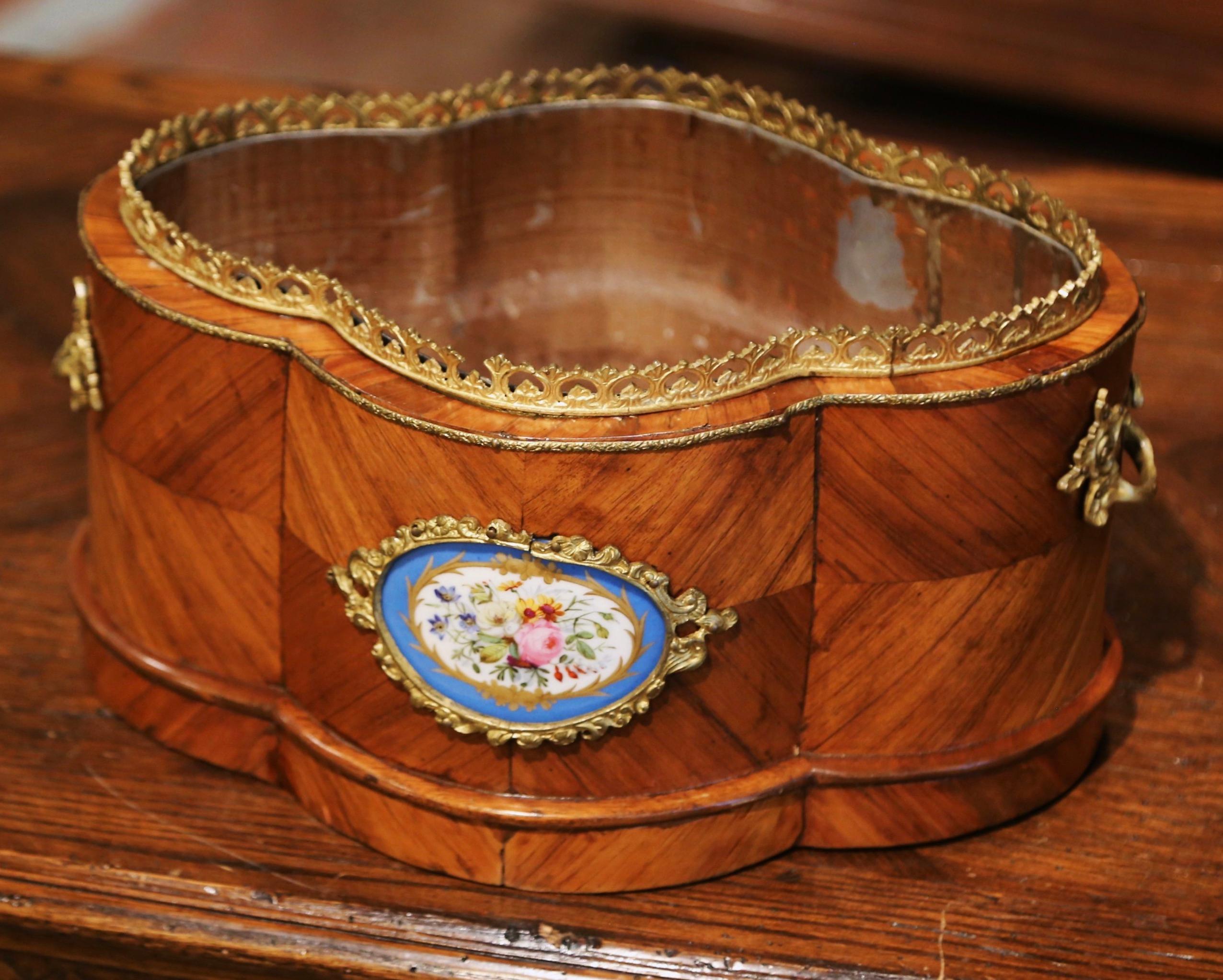 Decorate a dining table or a buffet top with this elegant, antique oval planter. Crafted in France circa 1870, and decorated with marquetry and parquetry motifs, the jardiniere with side handles, features a brass pierced gallery around the rim, and