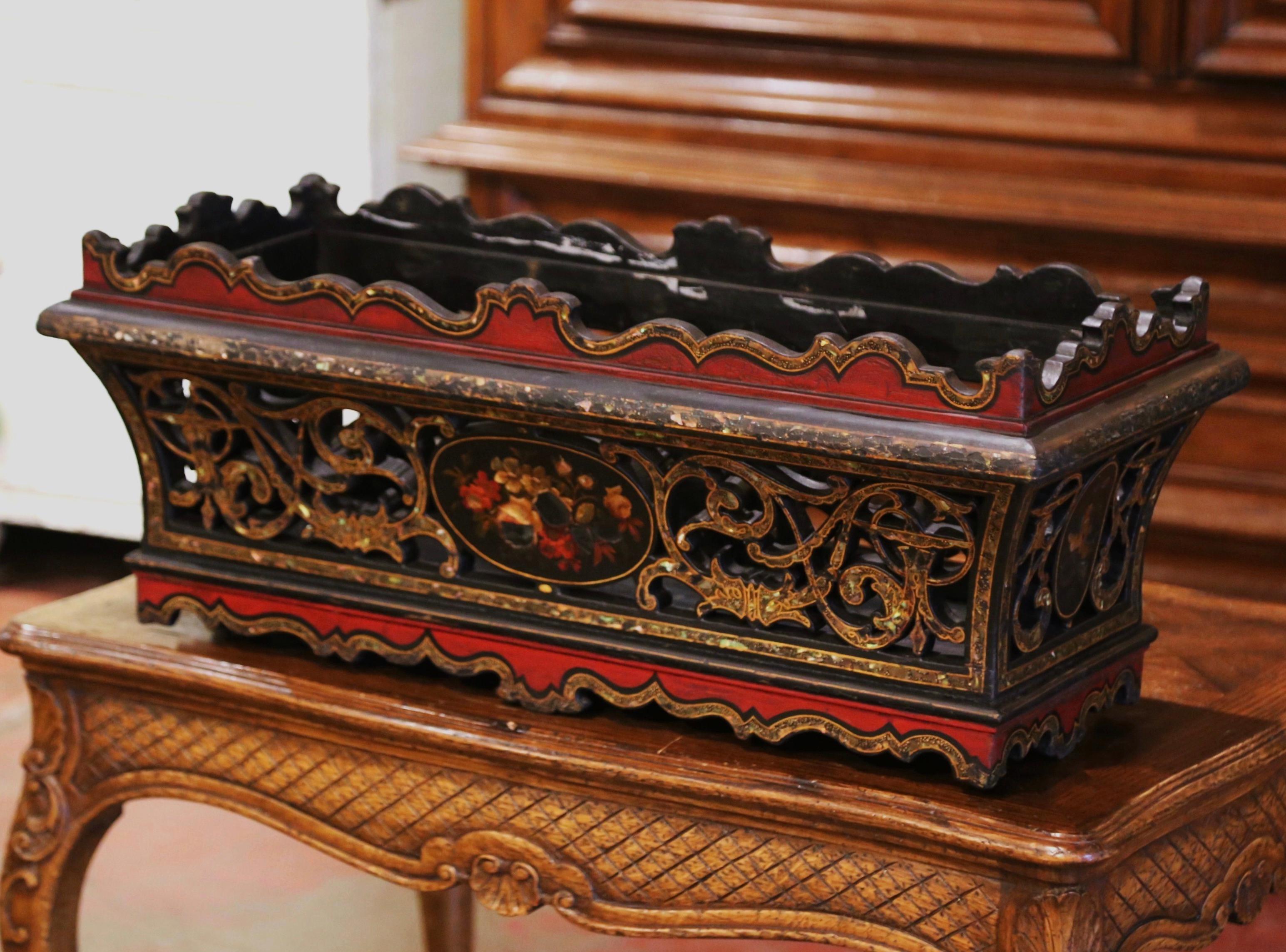 This colorful antique jardinière was created in France, circa 1880. Standing on a scalloped apron, the rectangular planter features pierced scrolled decor on all four sides, and is decorated with inlay mother of pearl motifs including a hand painted