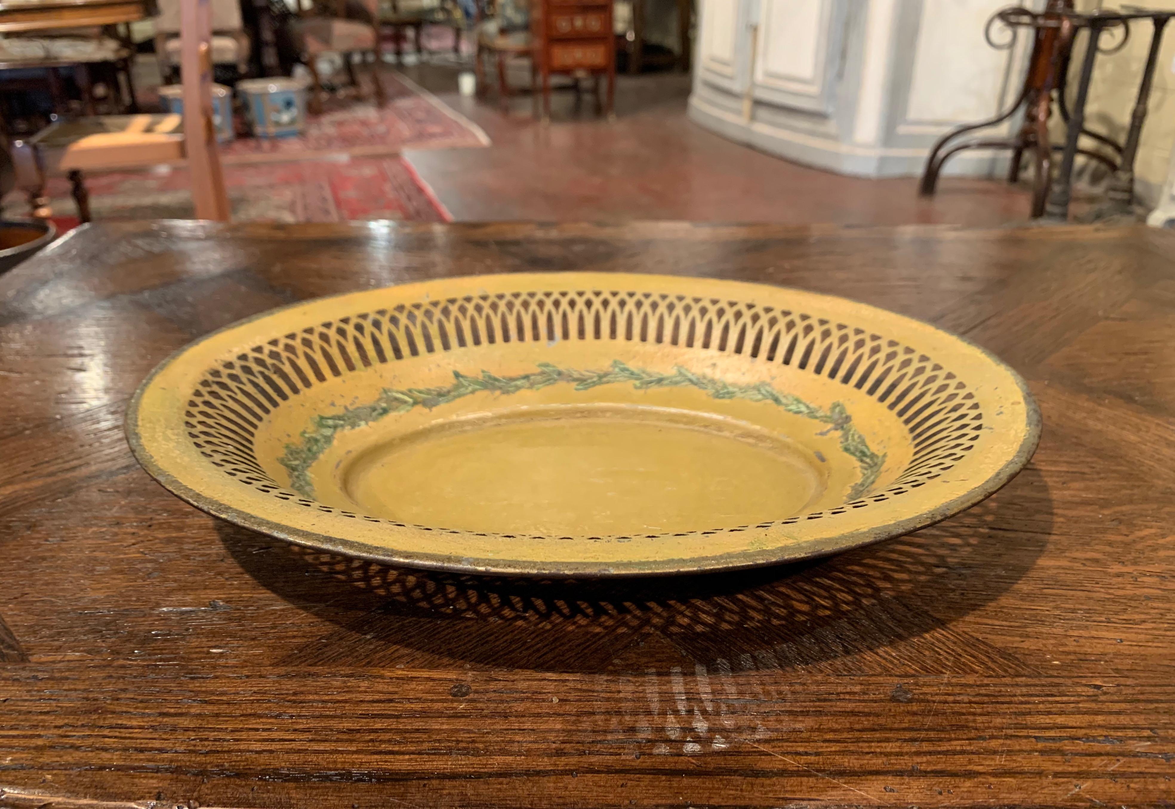 Display bread, crackers or fruit in this elegant antique basket; crafted in France circa 1880, the oval tole basket features a decorative pierced rim around the perimeter. The mustard painted bowl is hand painted with green floral motifs on the