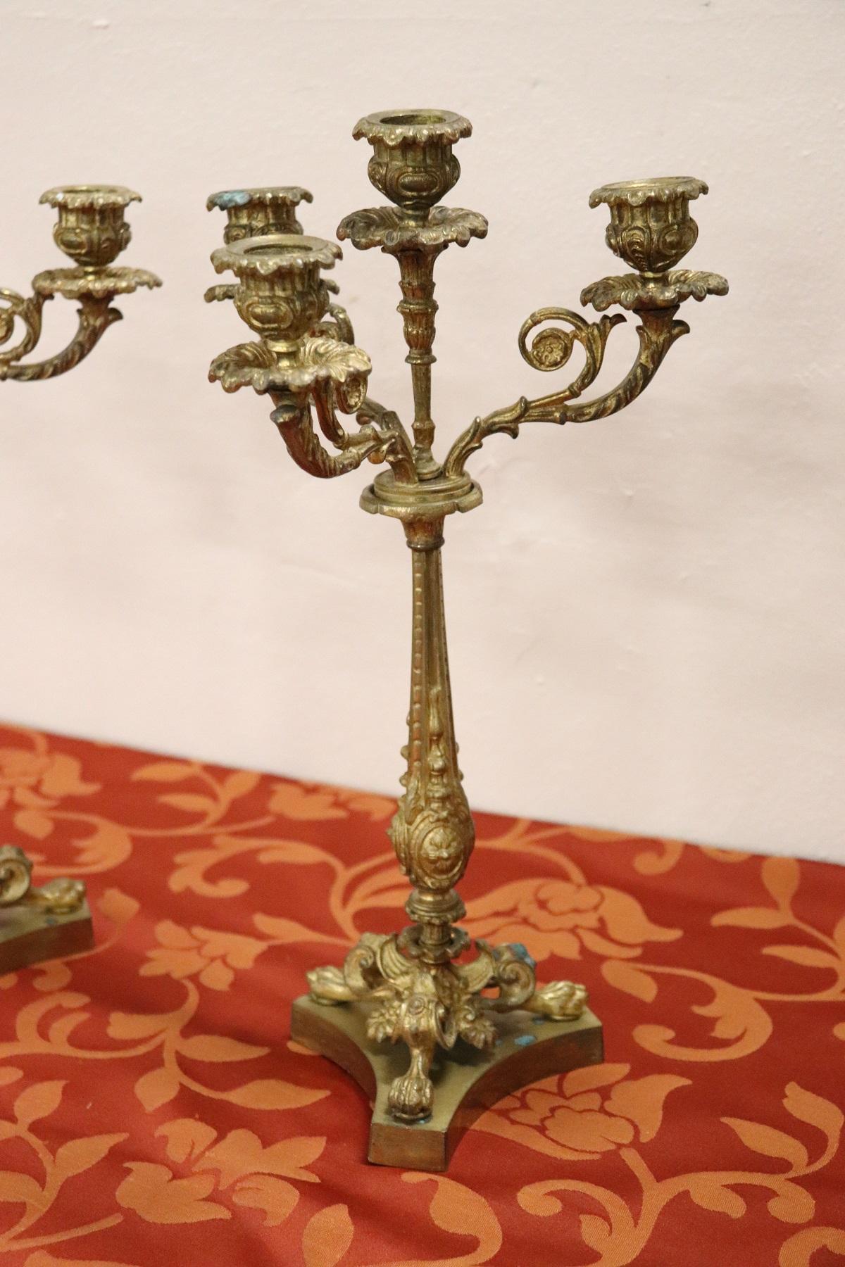 A particular pair of antique French Napoleon III candelabras in gilded bronze 4 arms. The bronze is finely chiselled decoration of great quality at the base of the lion's paw feet. Beautiful to decorate an important salon.