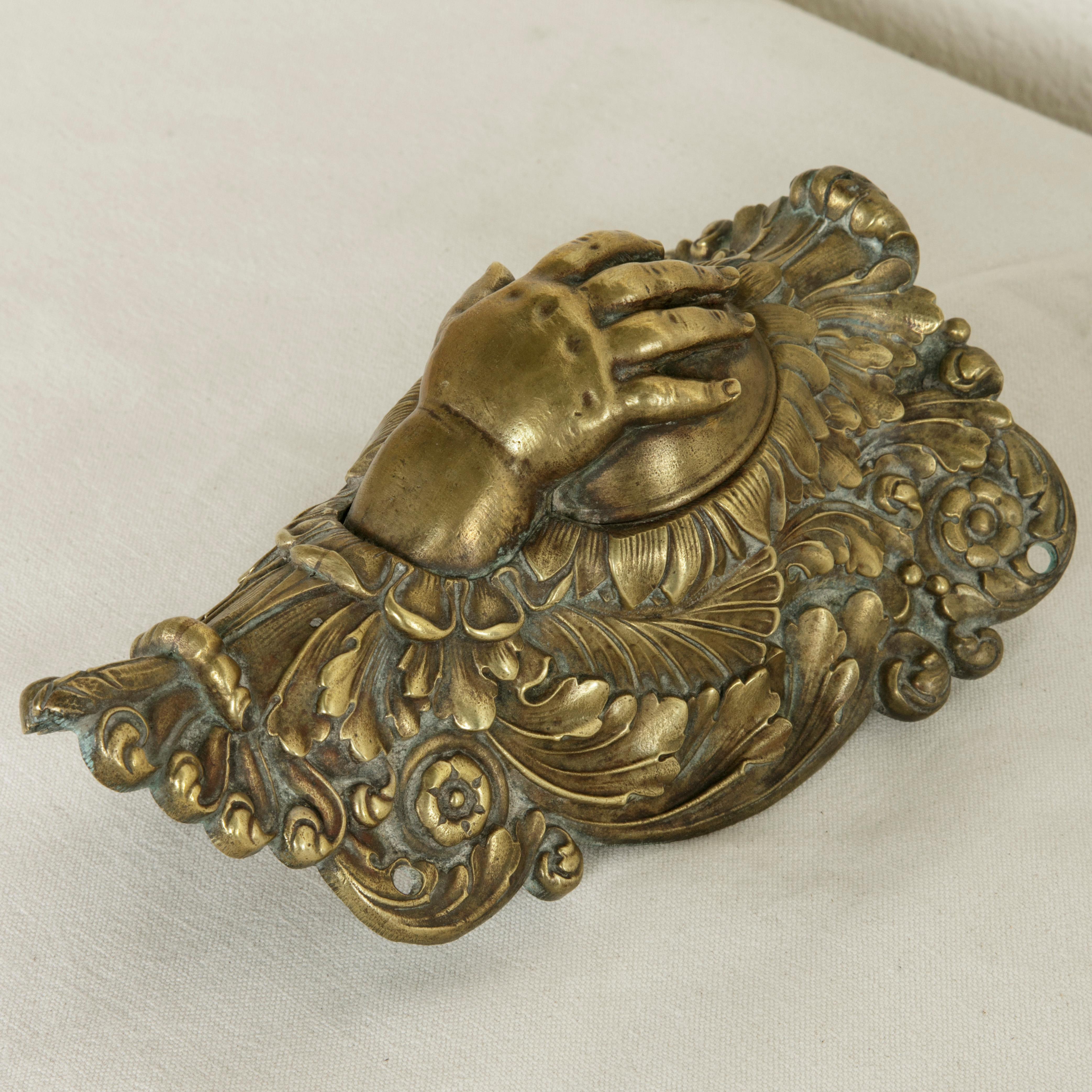 This 19th century Napoleon III period solid bronze billiard corner pocket features a dimpled child's hand. As a corner pocket on its original circa 1860 billiard table, the hand dropped forward to catch the billiard ball as it rolled into the