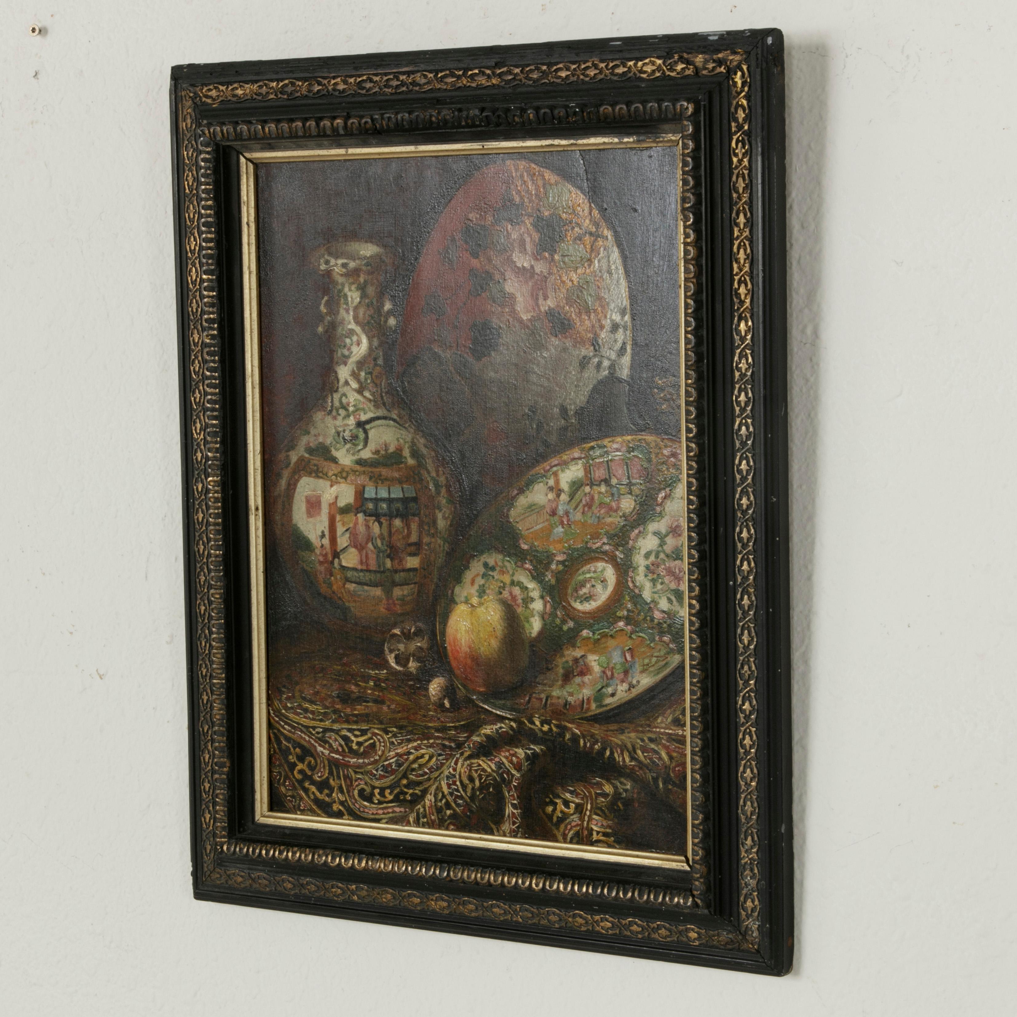 This late 19th century French Napoleon III period oil on panel painting features an orientalist still life with hand painted faience. An apple rests on the plate in the foreground and a fan detailed with leaves and flowers can be seen in the