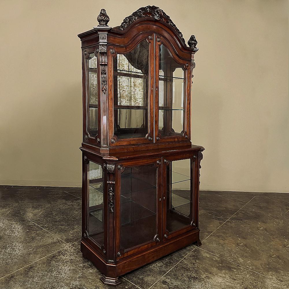 19th Century French Napoleon III Period Mahogany Bookcase ~ Vitrine is a marvel of fine artisanry, with elegantly arched crown festooned with hand-carved floral and foliates cascading down to the beautifully sculpted finials on the corner posts. 