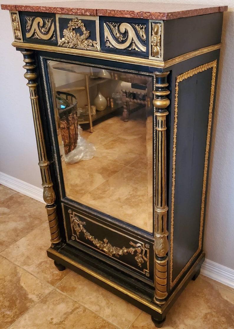 Un raro e magnifico mobile antico a un'anta a specchio del periodo Napoleone III, opera parigina, rifinito in un lussuoso e grandioso stile Luigi XIV.

Realizzato a mano a Parigi nel terzo quarto del XIX secolo, ha un piano in marmo Rosso Francia
