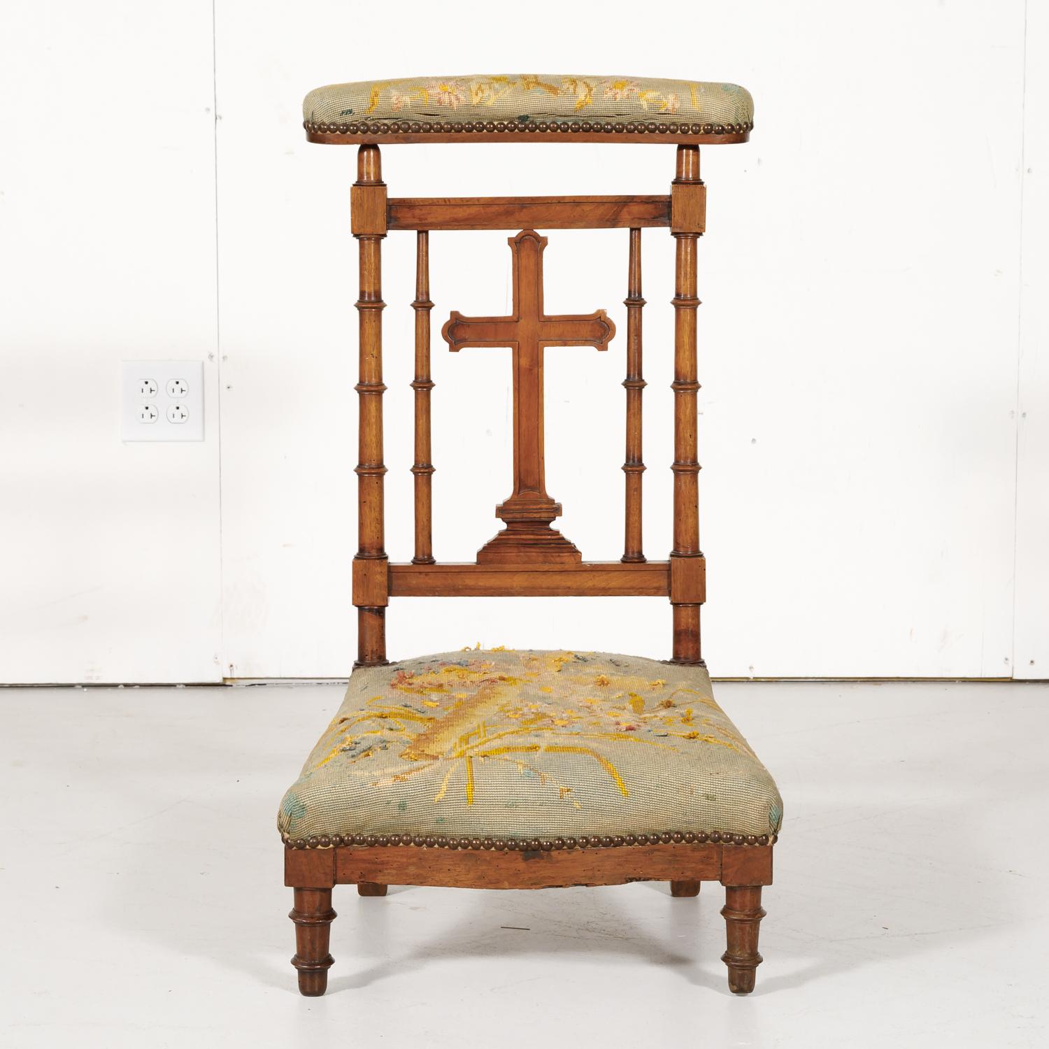 19th century French Napoleon III period prie dieu or prayer chair handcrafted and carved of solid walnut in Lyon, circa 1880s. This beautiful kneeling chair has its original covered, sloped top to rest one's arms or a prayer book with a hand carved