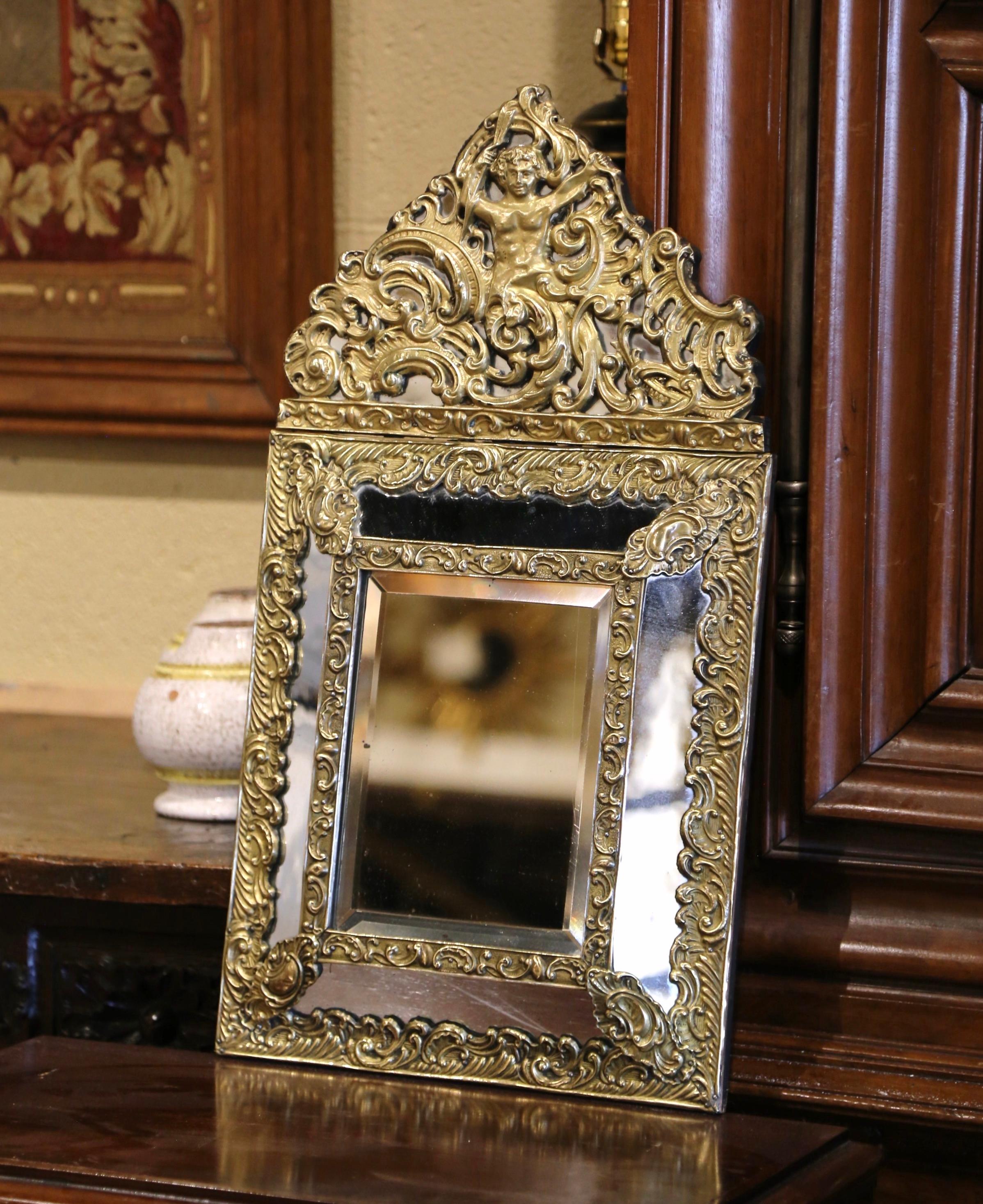 Creato in Francia, intorno al 1870, questo elegante specchio da parete antico è decorato con intricati decori in repousse, tra cui un cartiglio molto grande sul frontone con un dio greco centrale affiancato da volute e fogliame su entrambi i lati.