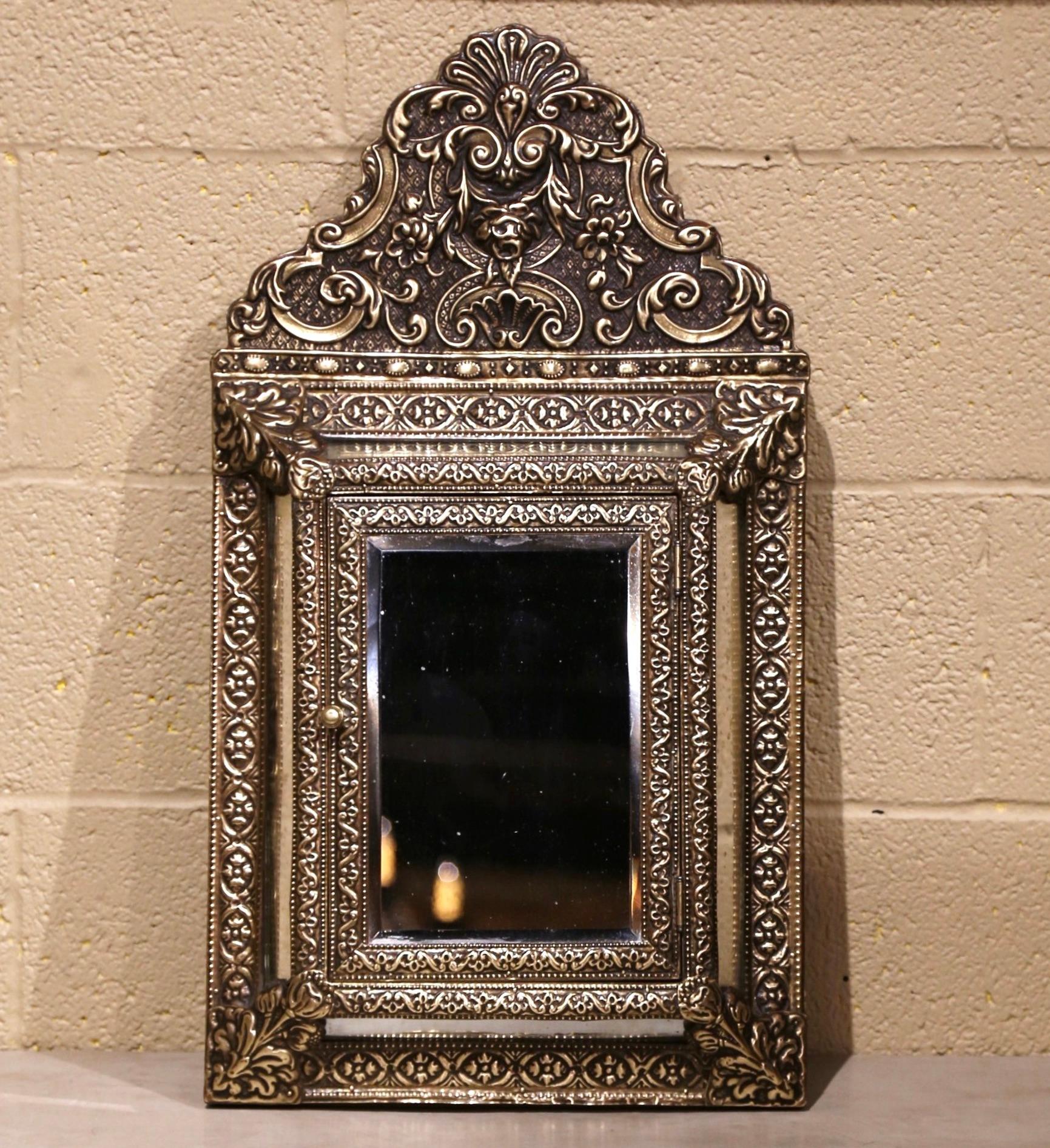 For ornate beauty with a secret compartment, look no further than this beautiful antique overlay brass mirror. Created in France, circa 1870, the petite mirror is decorated with intricate repousse motifs including a cartouche decor at the pediment.