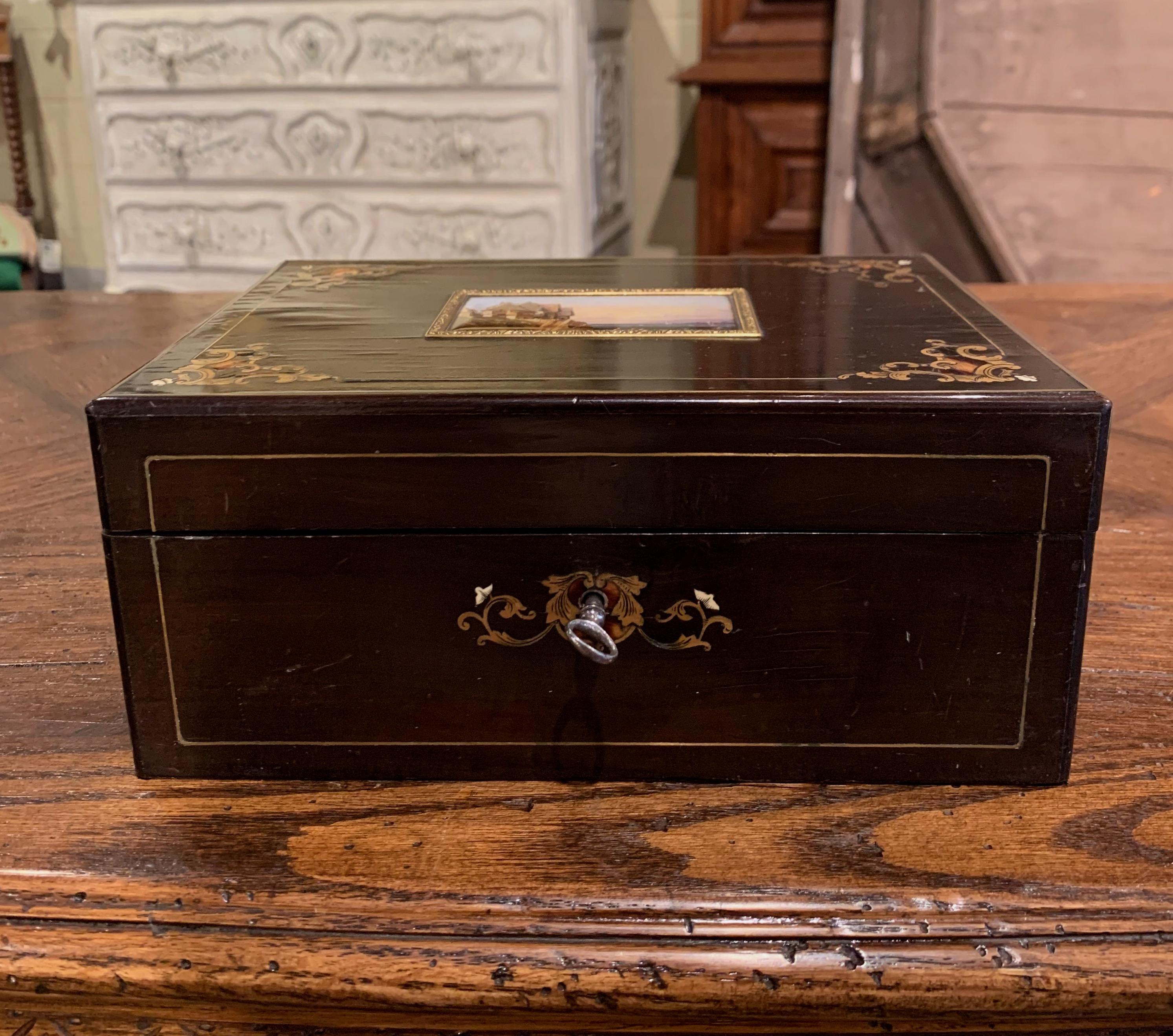Created in France circa 1880 in the manner of Andre Charles Boulle, the rectangular box, is decorated with arabesques of gilded brass inlay motifs in each corner and embellished with a central medallion with hand painted landscape scene. The inside