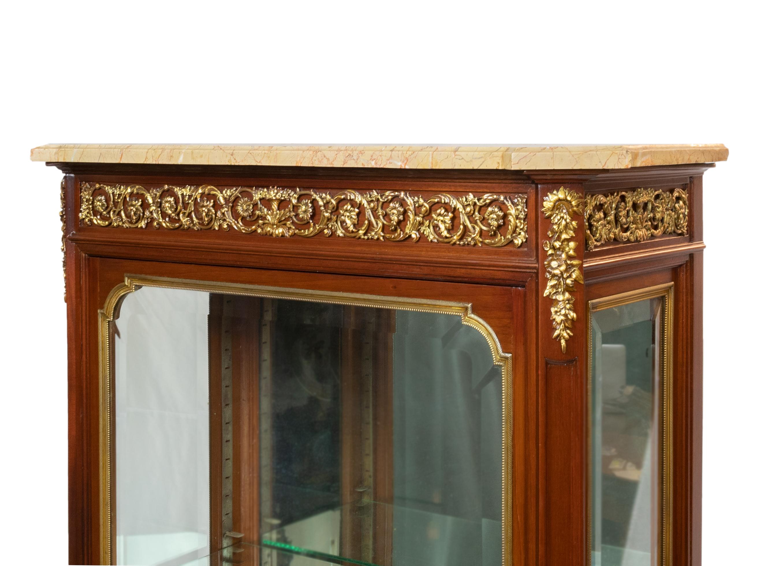A one-of-a-kind Napoleon III-style showcase, cabinet, or display case for bijouterie and jewels. Interior features a glass bottom, translucent glass shelves, corniced top, Cuba mahogany, marquetry, stamped gilded bronze, and a marble top.