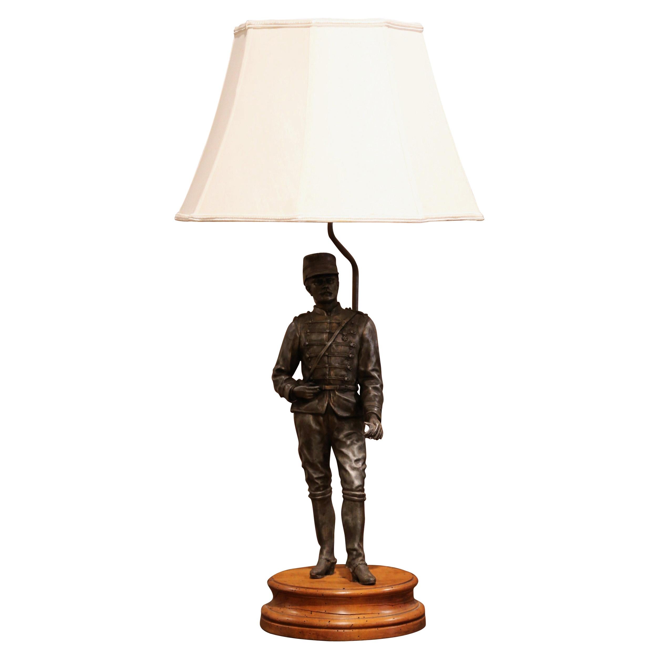 Décorez le bureau d'un homme avec cette lampe de table masculine antique, fabriquée en France vers 1880 et reposant sur une base ronde en noyer sculpté, la figurine représente un soldat français en uniforme Napoléon III. La lumière avec une tige
