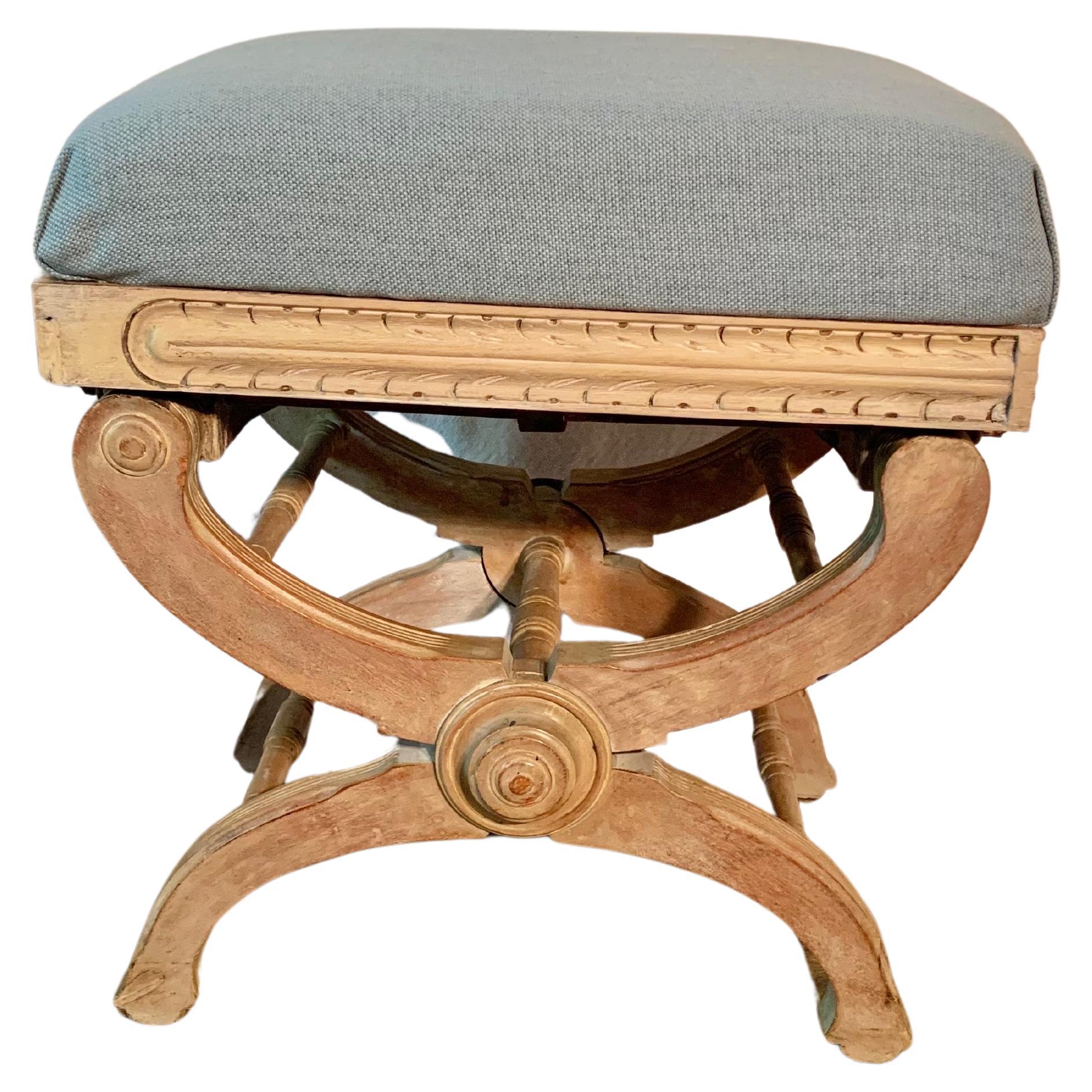 This 19th Century Napoleon III Style Adjustable Curule Stool or Bench was crafted by French artisans in the late 1800's. The piece features a newly upholstered top resting on a hand carved X form or half moon base supported by turned stretchers and