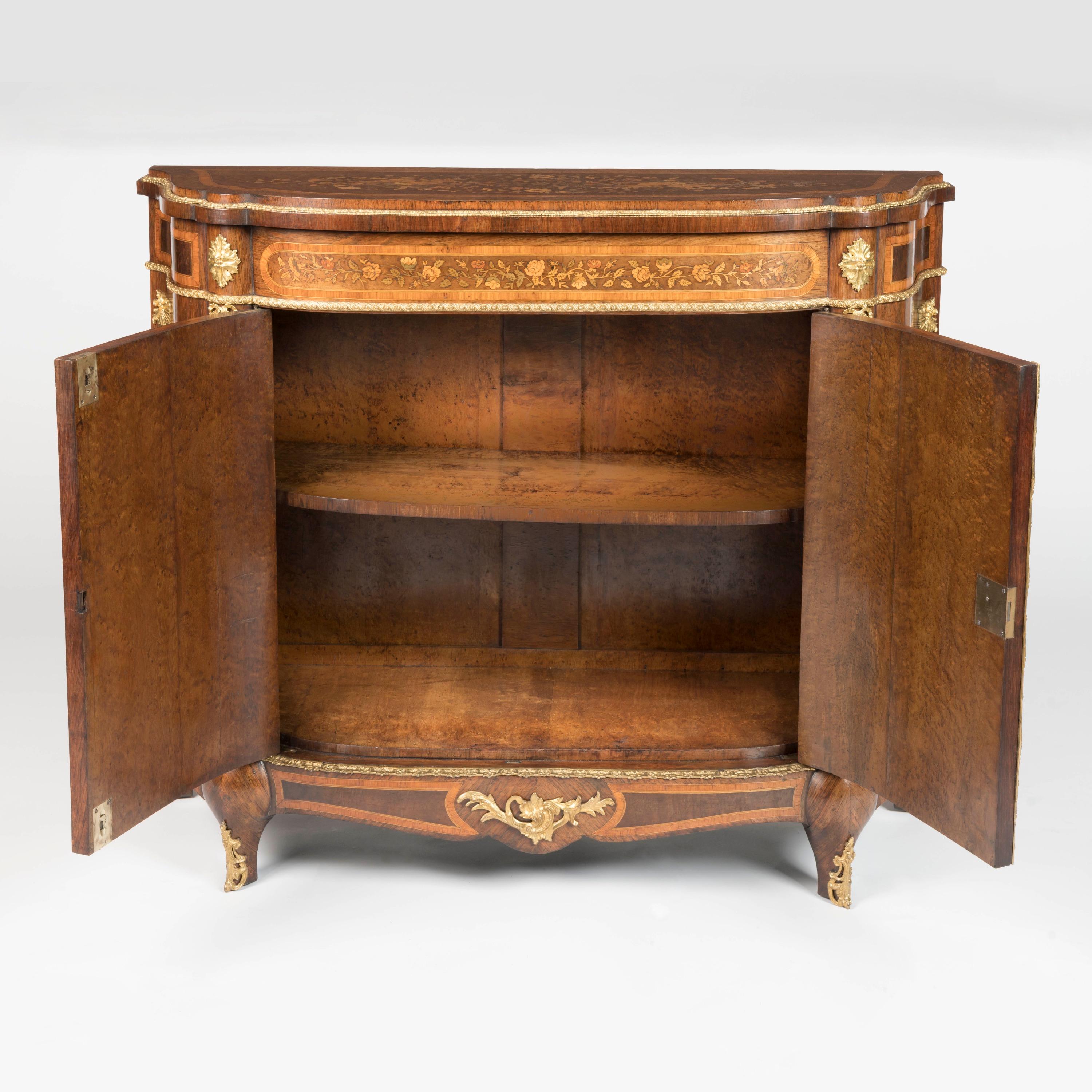 A Napoleon III Ormolu-Mounted Marquetry Meuble d'Appui

Of bow fronted arc-en-arbalette outline, the cabinet constructed using several fine woods including birds' eye maple, tulipwood, rosewood and harewood among others, dressed with gilt bronze