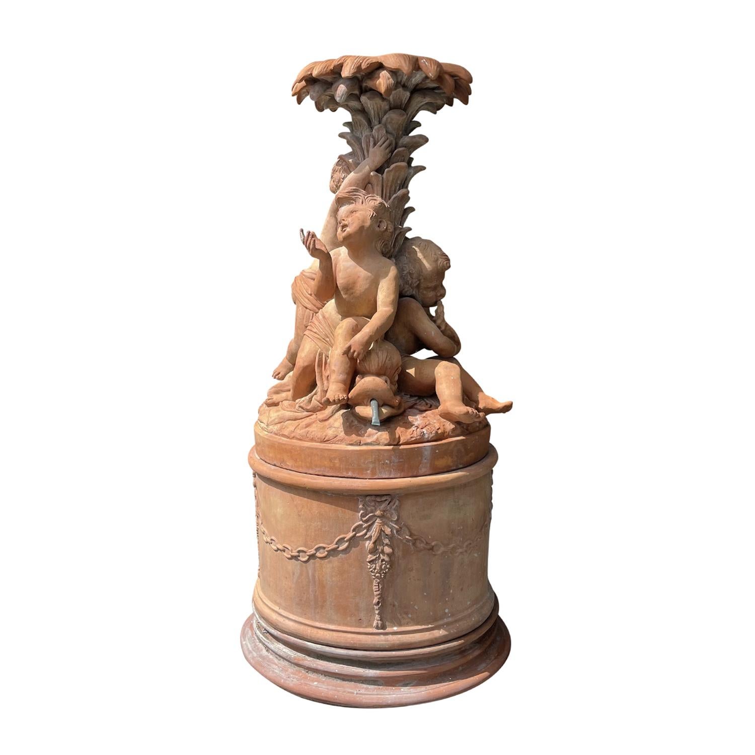 Un'antica testa di fontana in terracotta francese in stile Napoleone III con tre putti seduti su un grande delfino o delfino grottesco in diverse posizioni, in buone condizioni. I putti sono appoggiati alla grande e dettagliata coda di pesce su una