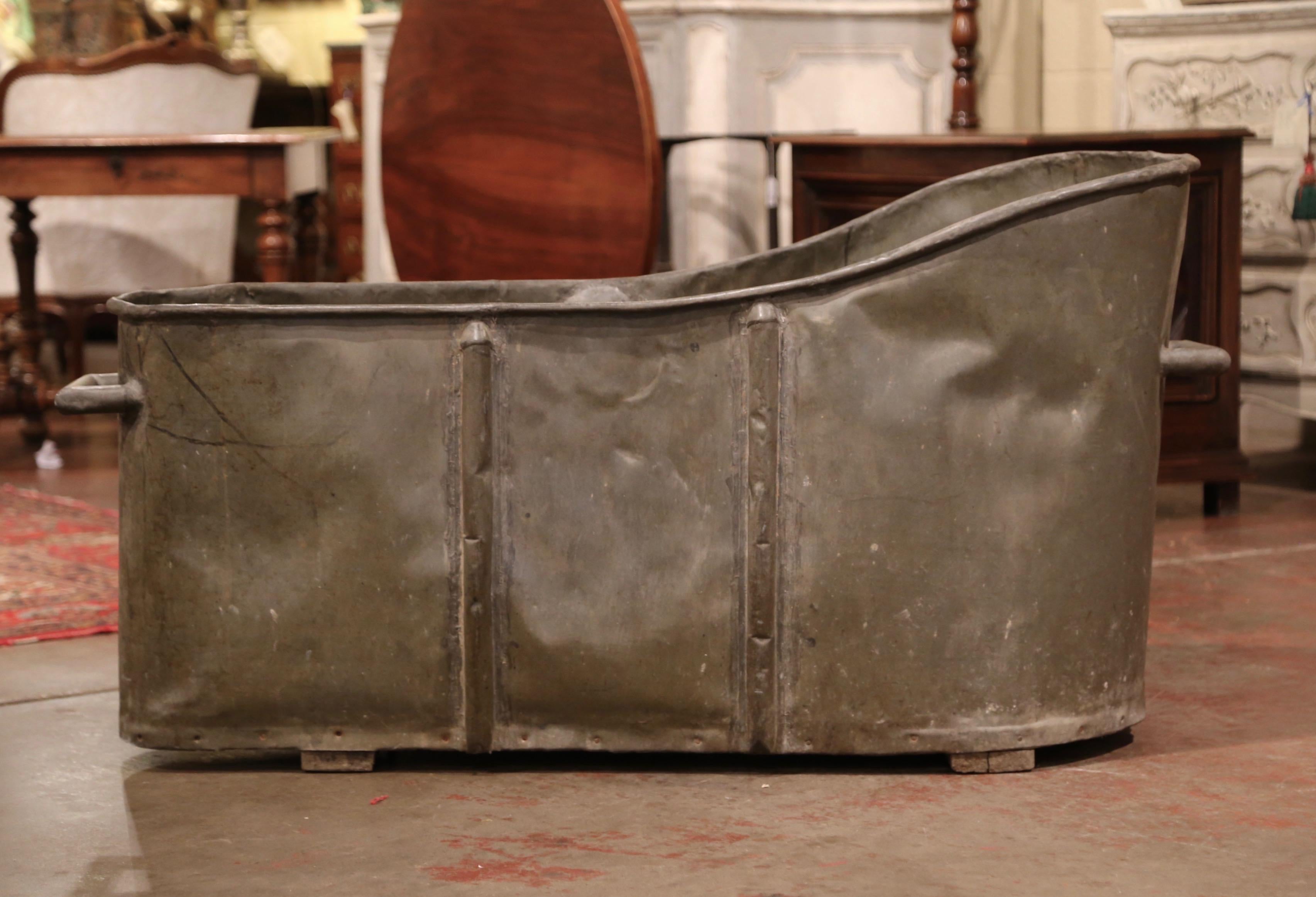 Use this decorative antique tub as a jardinière or a drink cooler! Crafted in France, circa 1880, and standing on a wood bottom, the oblong bathtub features a sturdy handle at one end and roll edges around the rim. The tub is in excellent condition