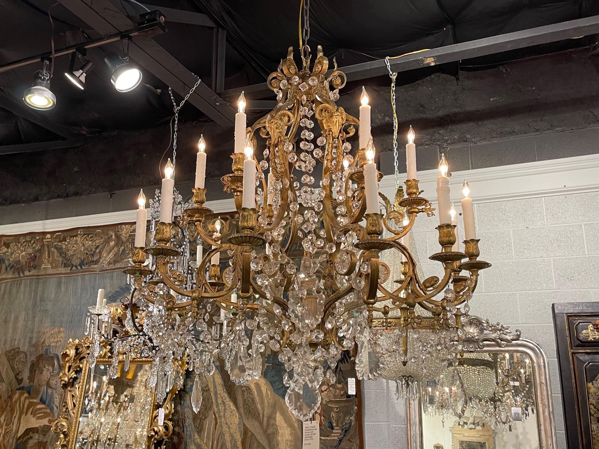 Extraordinary 19th century French neo classical bronze and crystal chandelier with 18 lights. Features bronze ram's heads at the top of the beautiful carved base, along with a plethora of gorgeous crystals. Superb!!