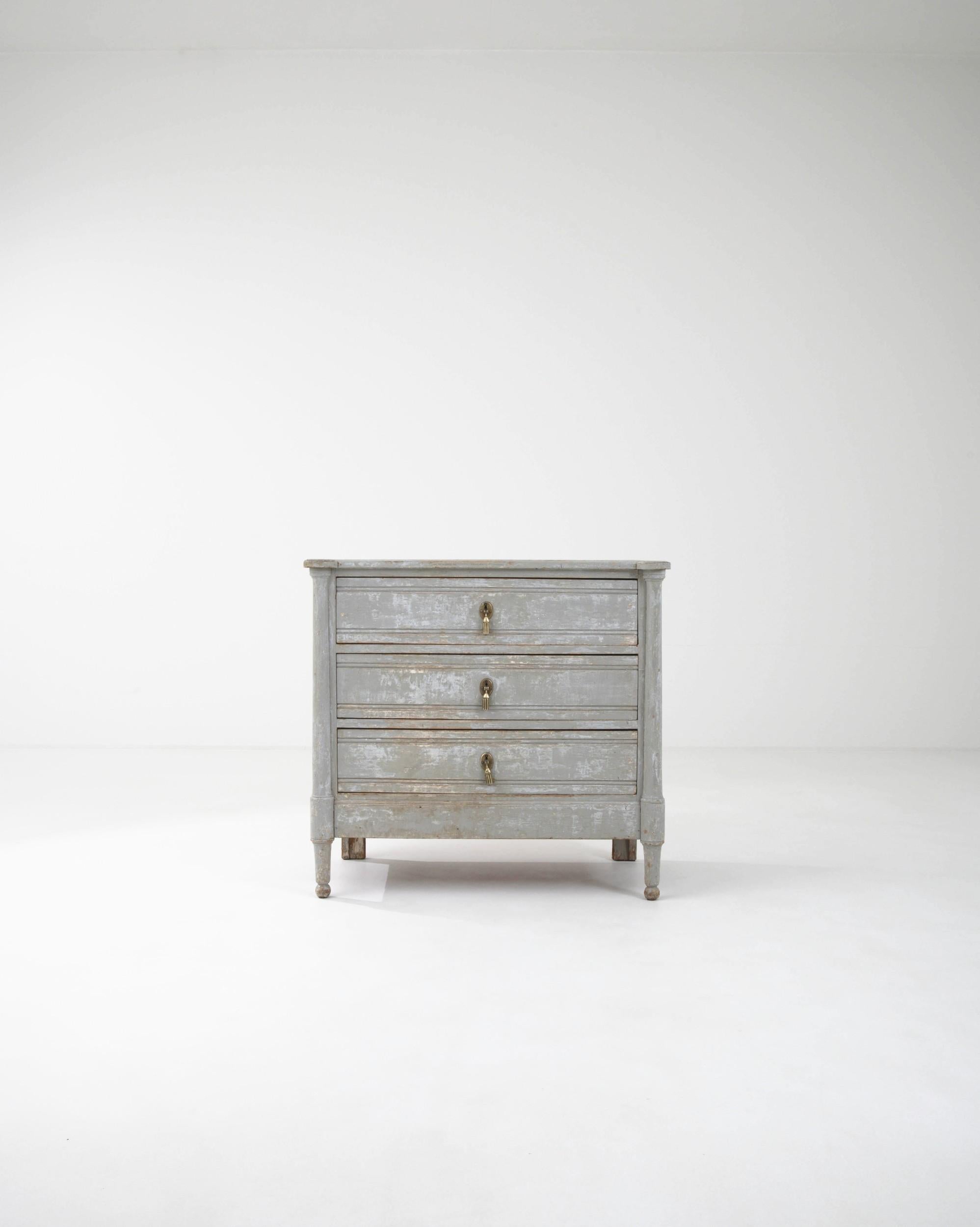 This antique wooden chest of drawers epitomizes the refinement of Neoclassical style. Hand-built in France in the 1800s, the graceful simplicity of the design is accentuated by the dove-grey patina of the painted finish, weathered over the centuries