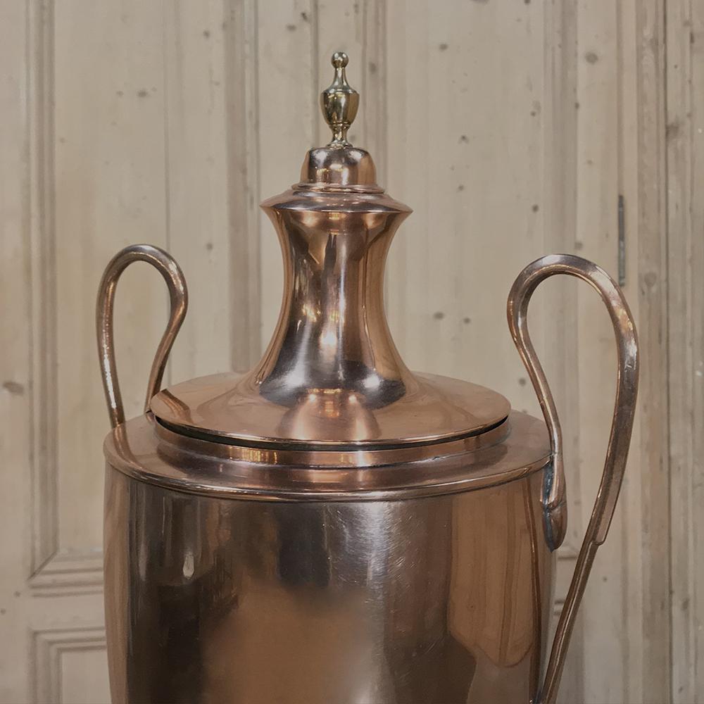 Elegant 19th century French neoclassical copper and brass tea server or coffee urn with a design inspired by ancient Greek Amphora. The urn featuring a lovely copper and brass body with two graceful swan-neck handles, and a brass finial on top of