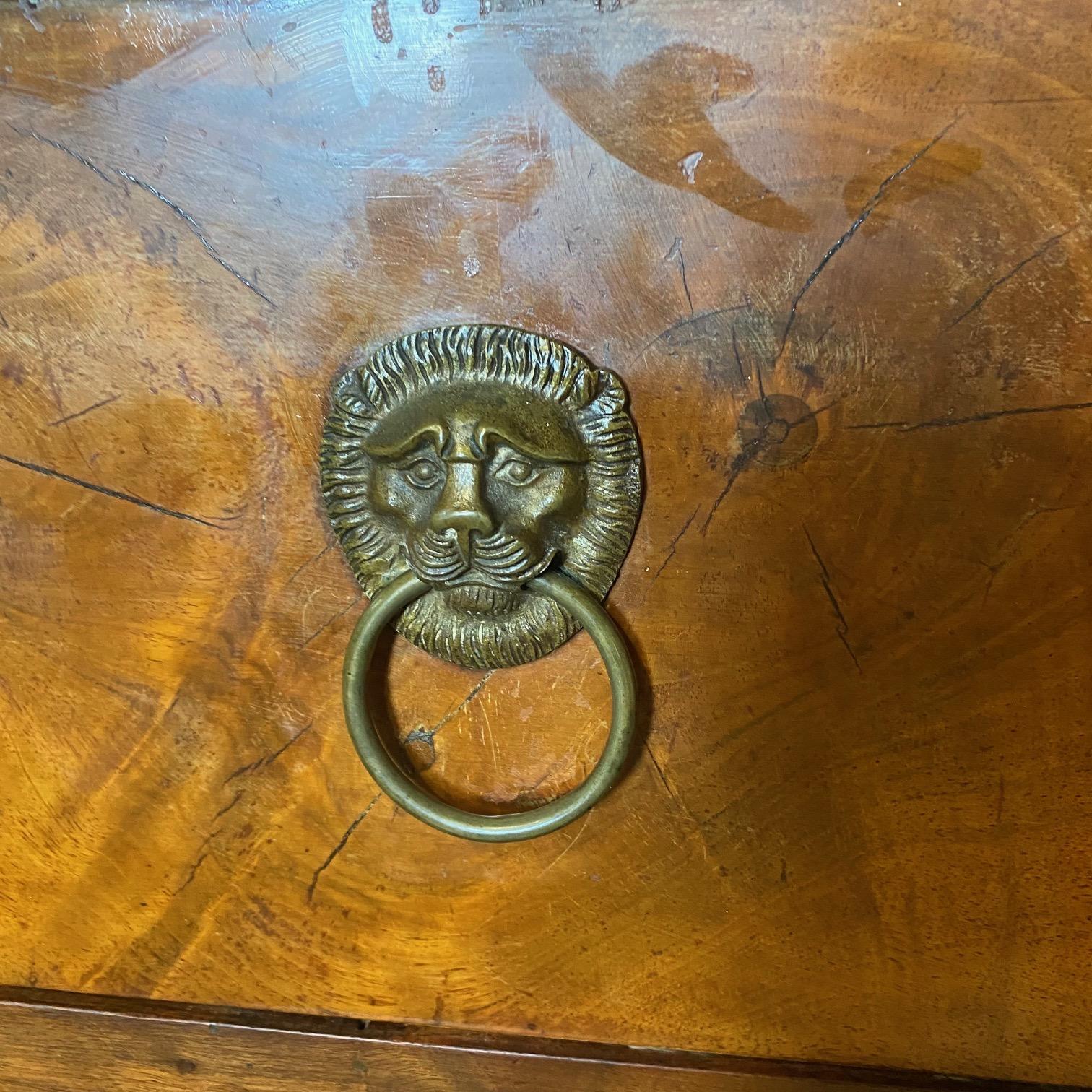 Una squisita commode neoclassica a due cassetti in stile Directoire dell'inizio del XIX secolo. La cassettiera è impreziosita da originali tiretti a testa di leone su ciascuno dei cassetti, oltre che da rosette a forma di cresta ornate da disegni