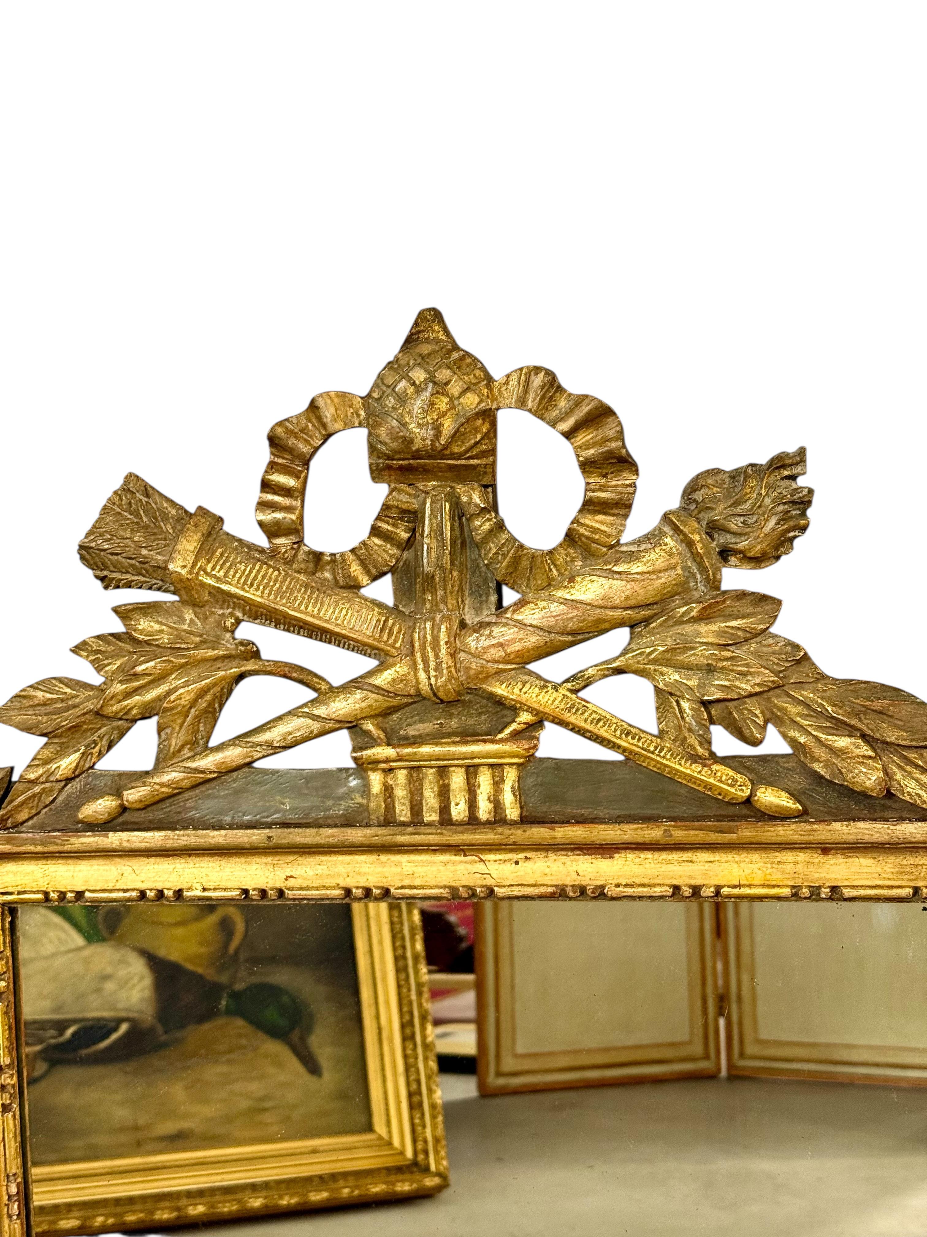 Questo squisito specchio trumeau francese è un ottimo esempio di artigianato del XIX secolo, che fonde l'eleganza neoclassica con ornamenti ricchi di dettagli. Realizzata in legno intagliato e impreziosita dall'originale finitura dorata, la cornice