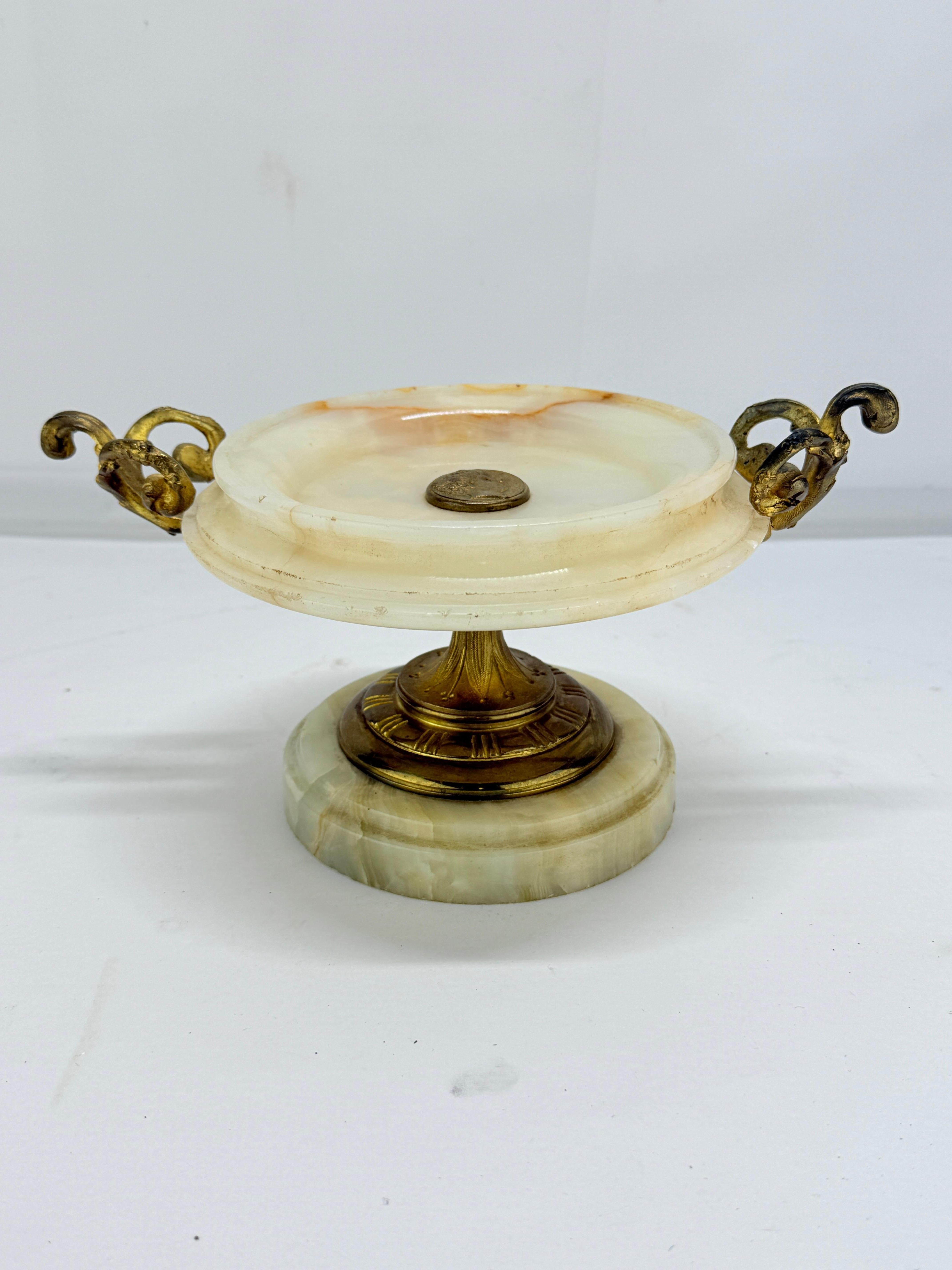 Tazza neoclassica francese in onice e bronzo dorato della fine del XIX secolo o dell'inizio del XX, probabilmente prodotta nel periodo dell'Empire revival. Questa composta ornamentale finemente lavorata presenta un piatto circolare di onice bianco