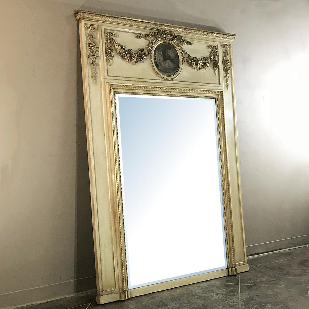 A wonderful example of a decorative element popular in France for over 400 years, this 19th Century French Neoclassical Painted Trumeau features an embossed design atop the mirror, with timeless architecture and embellishment that dates back to the