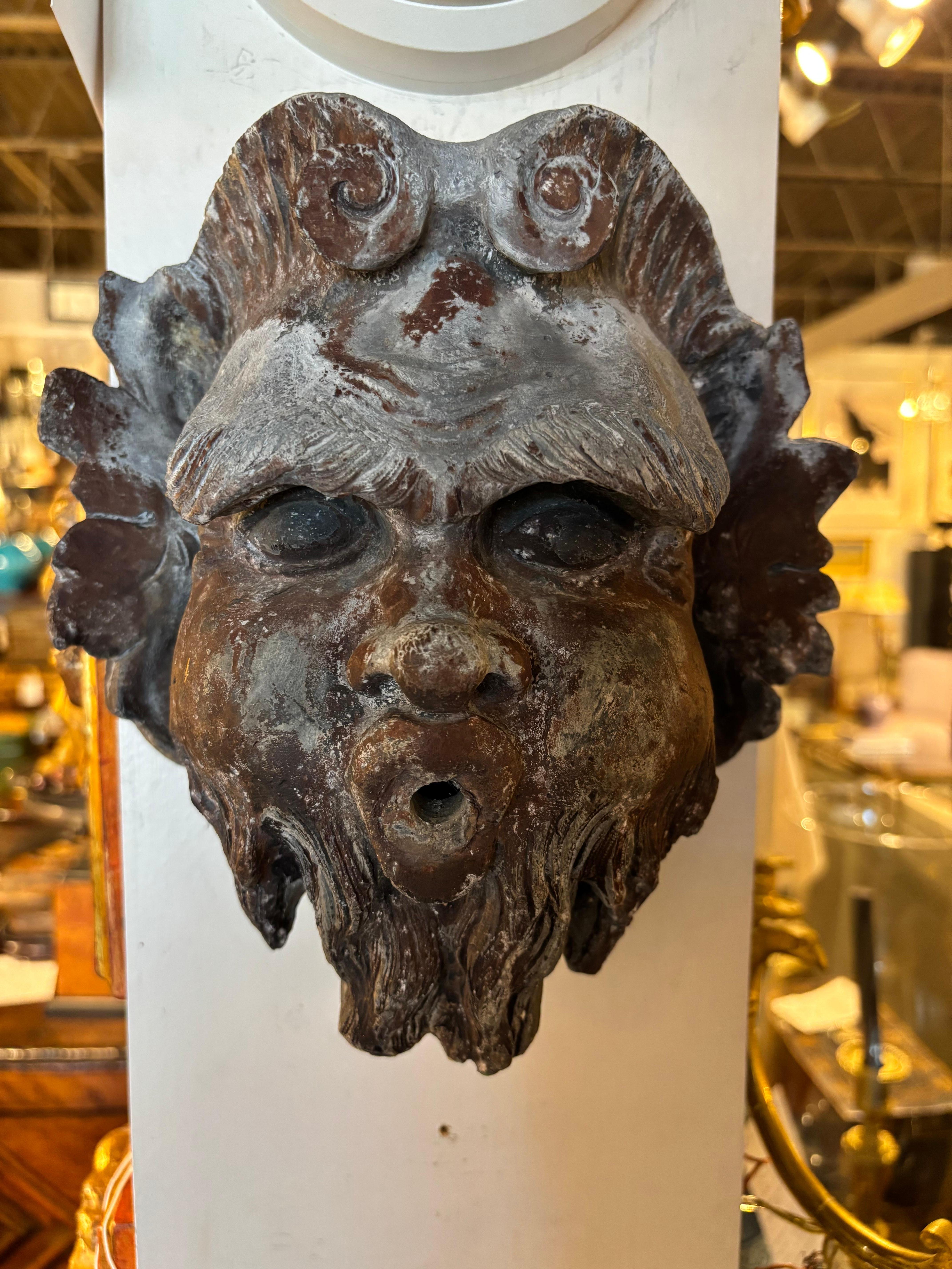 Máscara de plomo francesa del siglo XIX de una cabeza de fuente de un dios del río. La expresión feroz de su rostro mientras sopla agua por la boca hace de ella una escultura cautivadora.  Maravillosa superficie, con pintura antigua marrón rojiza y