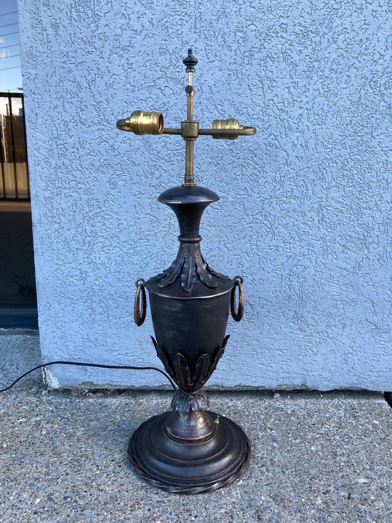 Urn form steel lamp with brass oval rings on the sides and repousse acanthus leaf decoration, the base with a twisted rope form wrought iron border. Wonderful metalwork, a very handsome piece. Neoclassical style, French circa 1890. Newly rewired.