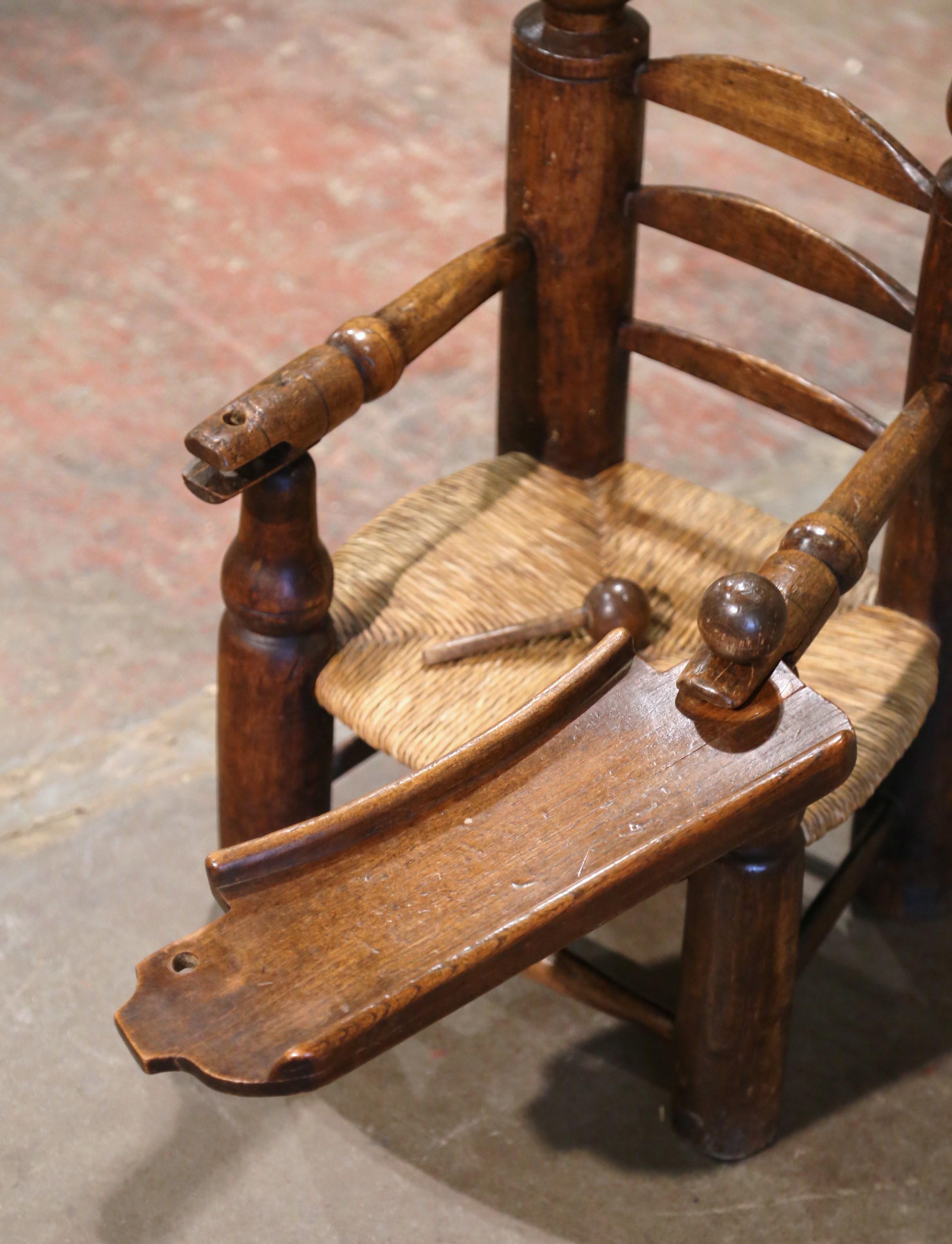 Füttern Sie Ihr Baby stilvoll in dem antiken Kinderstuhl mit aufgesetztem Futtertisch. Der um 1870 in der Normandie, Frankreich, aus Eichenholz gefertigte niedrige Stuhl steht auf vier gedrechselten Beinen, die mit einer unteren Bahre enden. Die